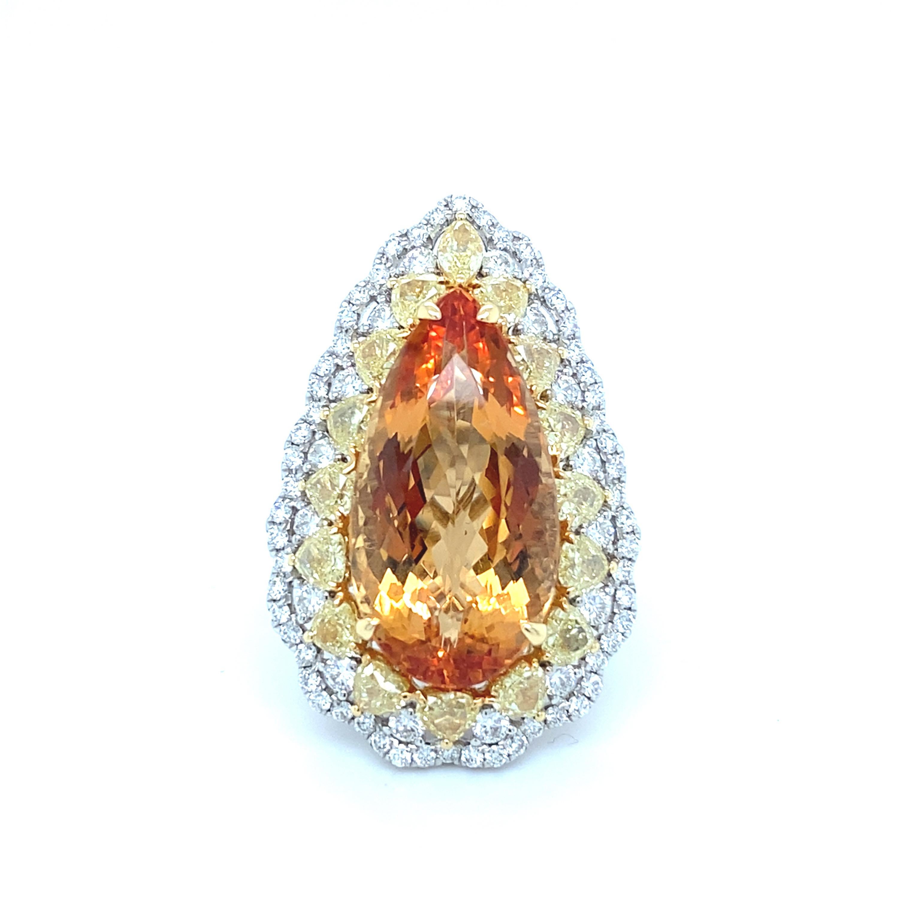 This exquisite 19.28-carat pear-cut imperial topaz is set in 18K two-tone gold, with the center stone beautifully framed by a scalloped design of 4.93 carats of round yellow and white diamonds. The imperial topaz, with its stunning sunset yellow