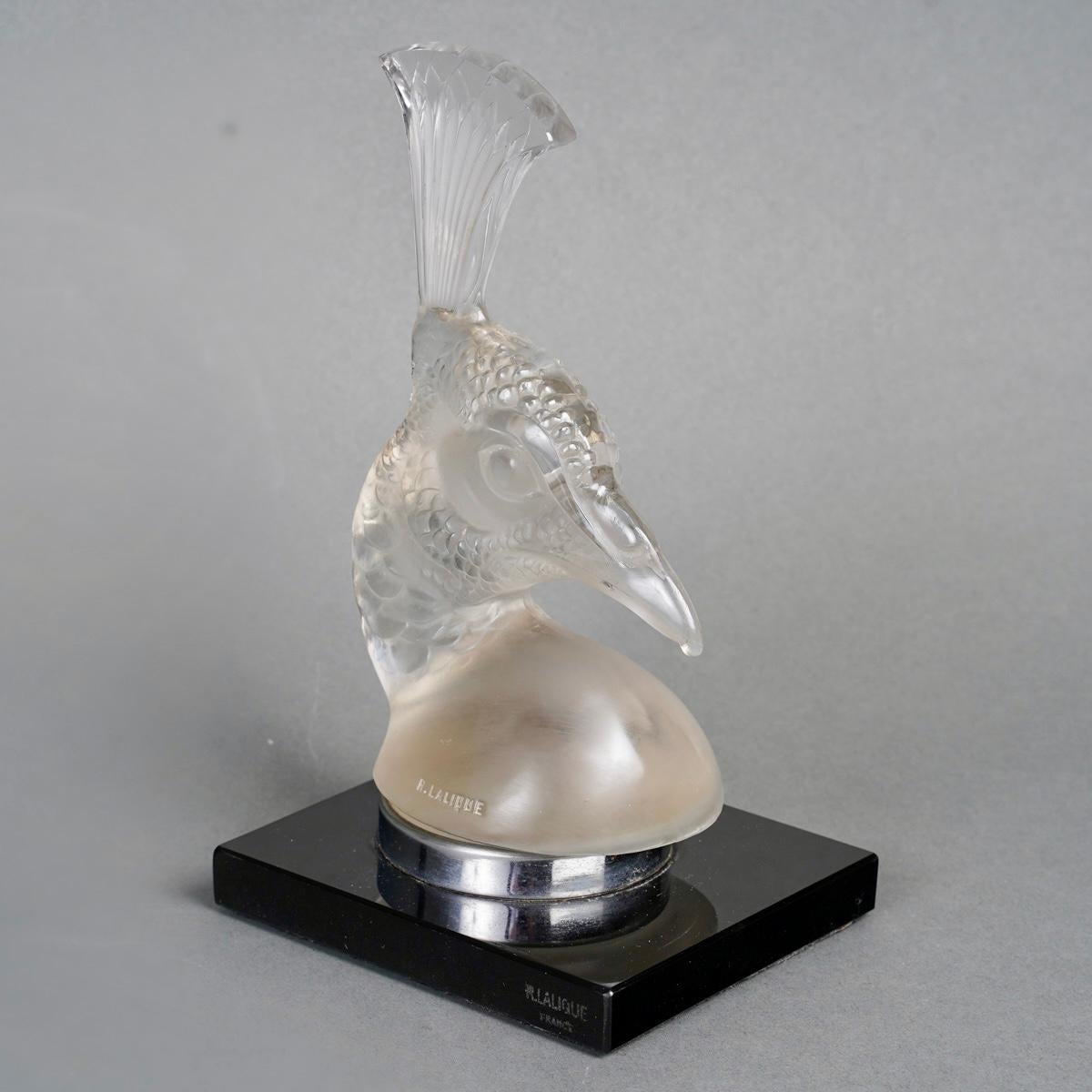 Car mascot Tête de Paon (Peacock Head) made in frosted glass by René Lalique in 1928.
Originally mounted as a bookend on a black glass base.
Molded signature on the mascot and stamped one on base.

Perfect condition.

Height: 20 cm

Félix Marcilhac,