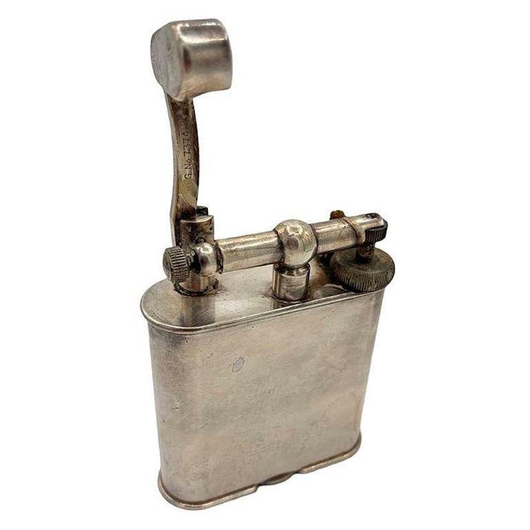 Original 1928 Dunhill Silver-plate Lift Arm Table Lighter, standing at 4 1/2 inches tall, exudes timeless sophistication. Crafted in England with a PAT 390107 stamp, it features a sleek silver-plated finish that reflects the brand's commitment to