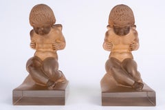 1929 René Lalique – Paar Buchstützen „Amour Putti“ aus Glas mit sepiafarbener Patina