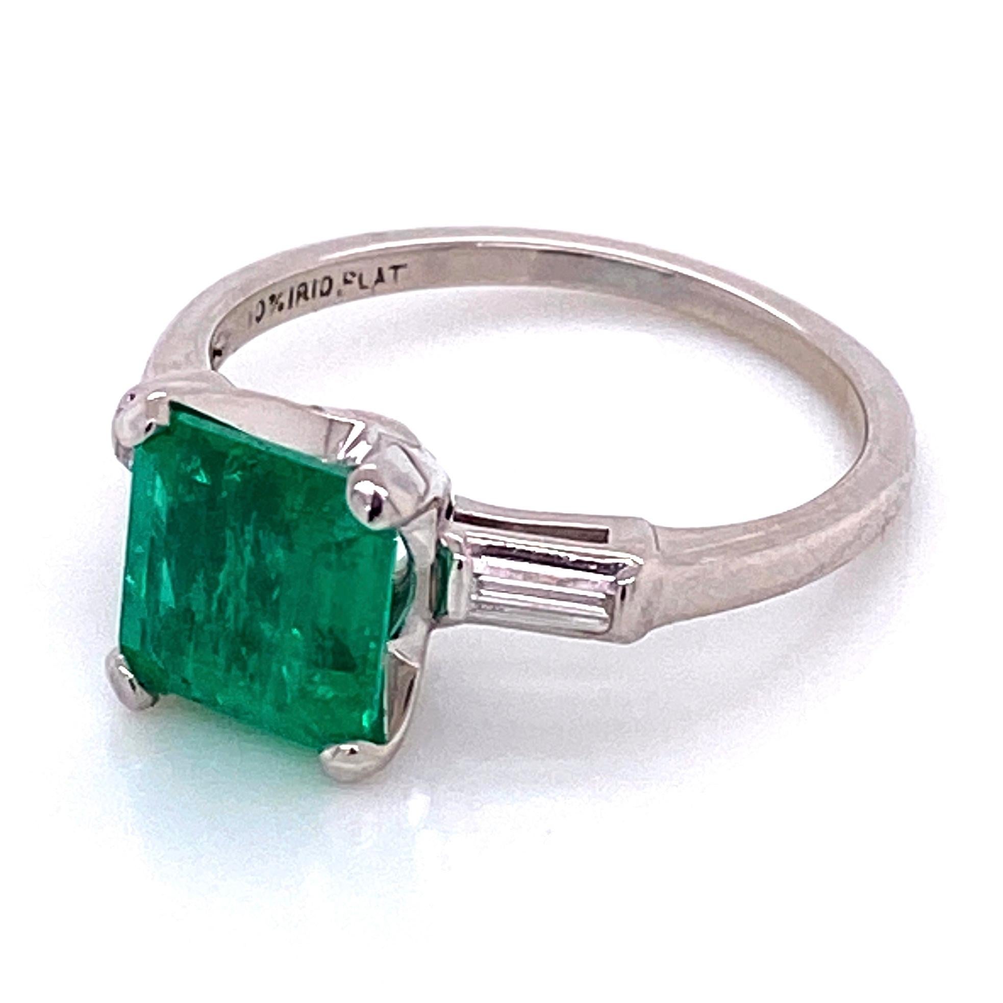 Classic and finely detailed Emerald and Diamond Ring, center securely set with a 1.93 Carat Square Emerald Cut Vibrant Green Emerald and Baguette Diamonds weighing .25 total carat weight on either side. Hand crafted Platinum mounting. Ring size 7.