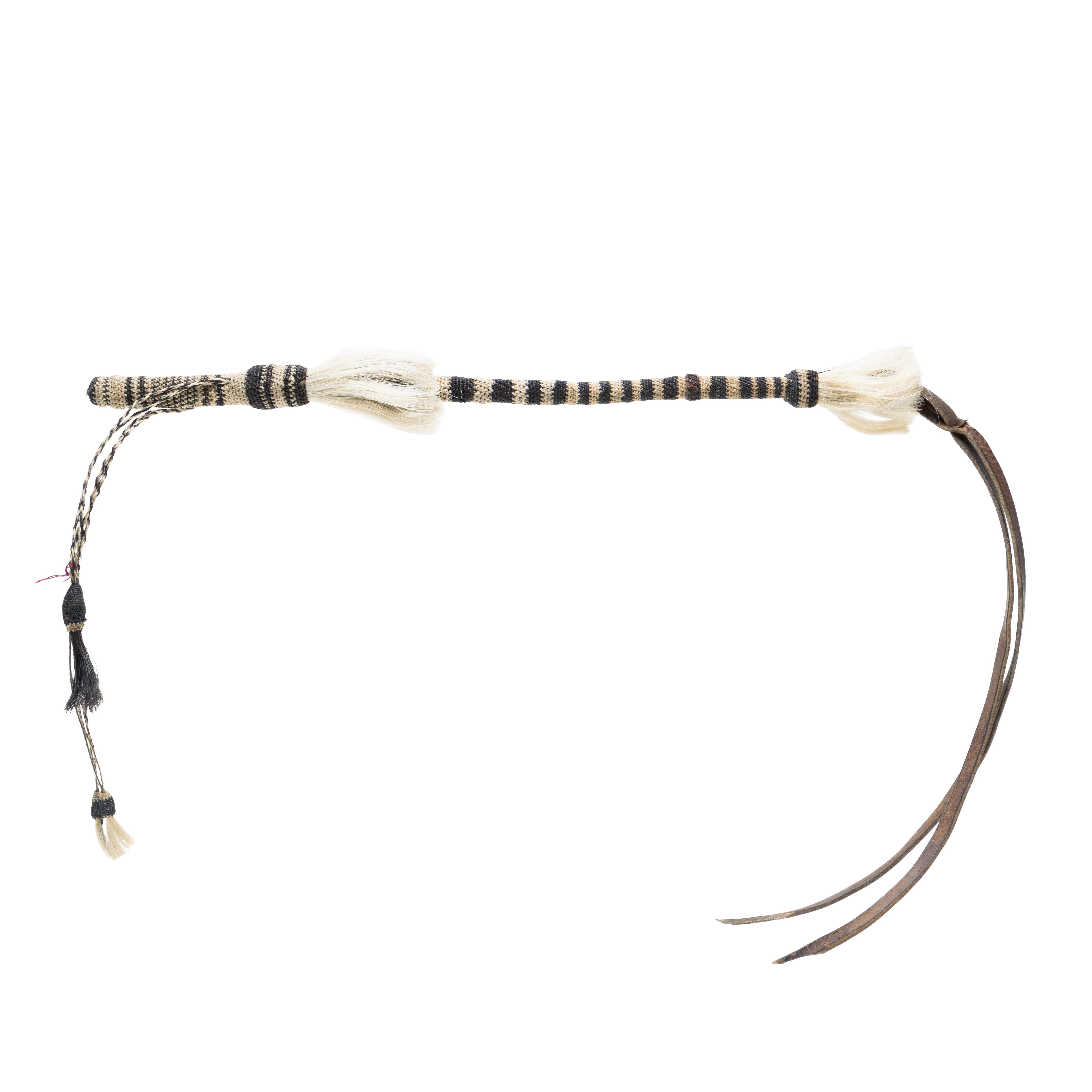 Horsehair quirt with original leather flapper and buttons. Like new condition. From Montana. Whitish/cream and black stripes and braided horse hair. 
PERIOD: First Half 20th Century
ORIGIN: Montana, United States
SIZE: 18