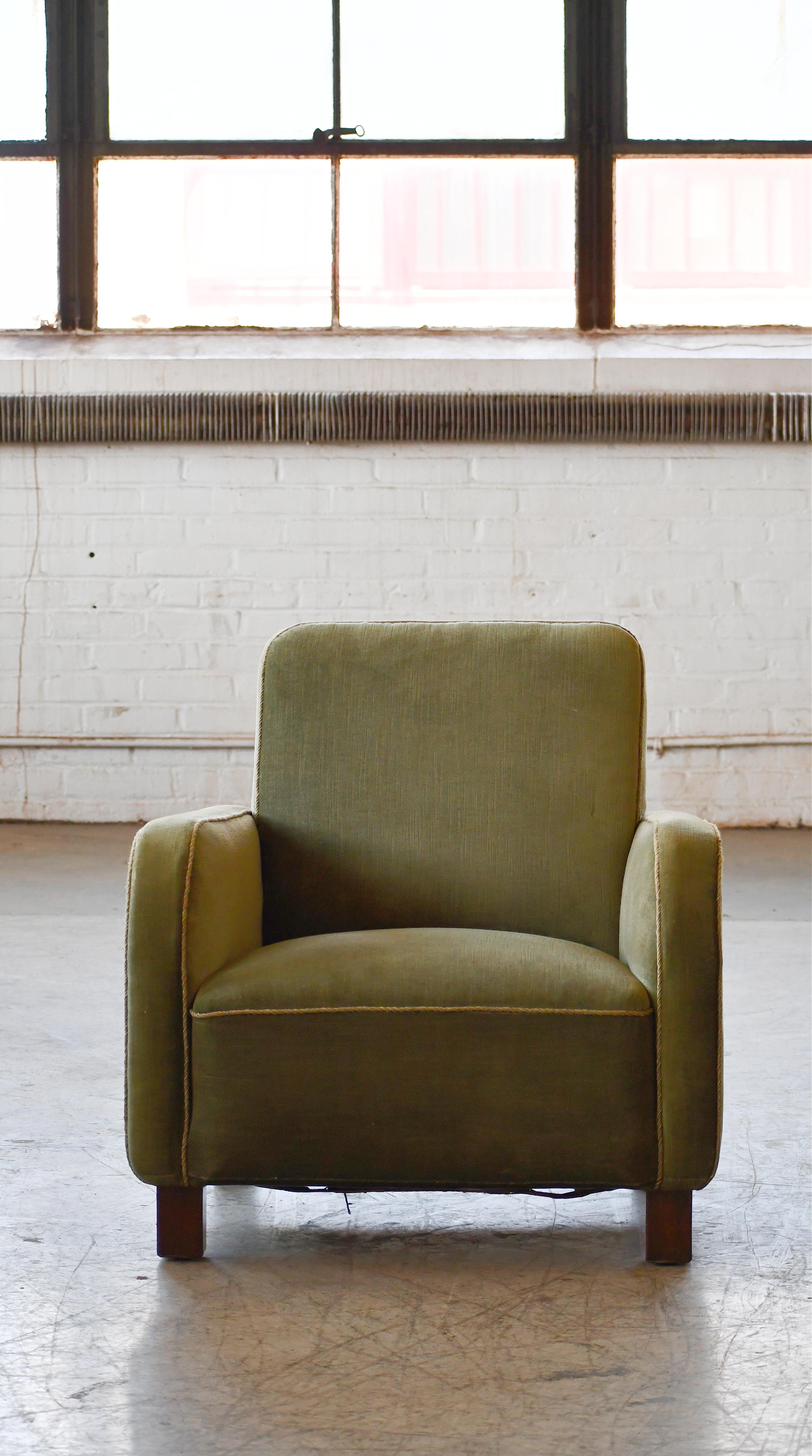 Curvy and eye-catching Danish club chair from the 1930s or 1940s. Set on mahogany feet the design is typical of the art 