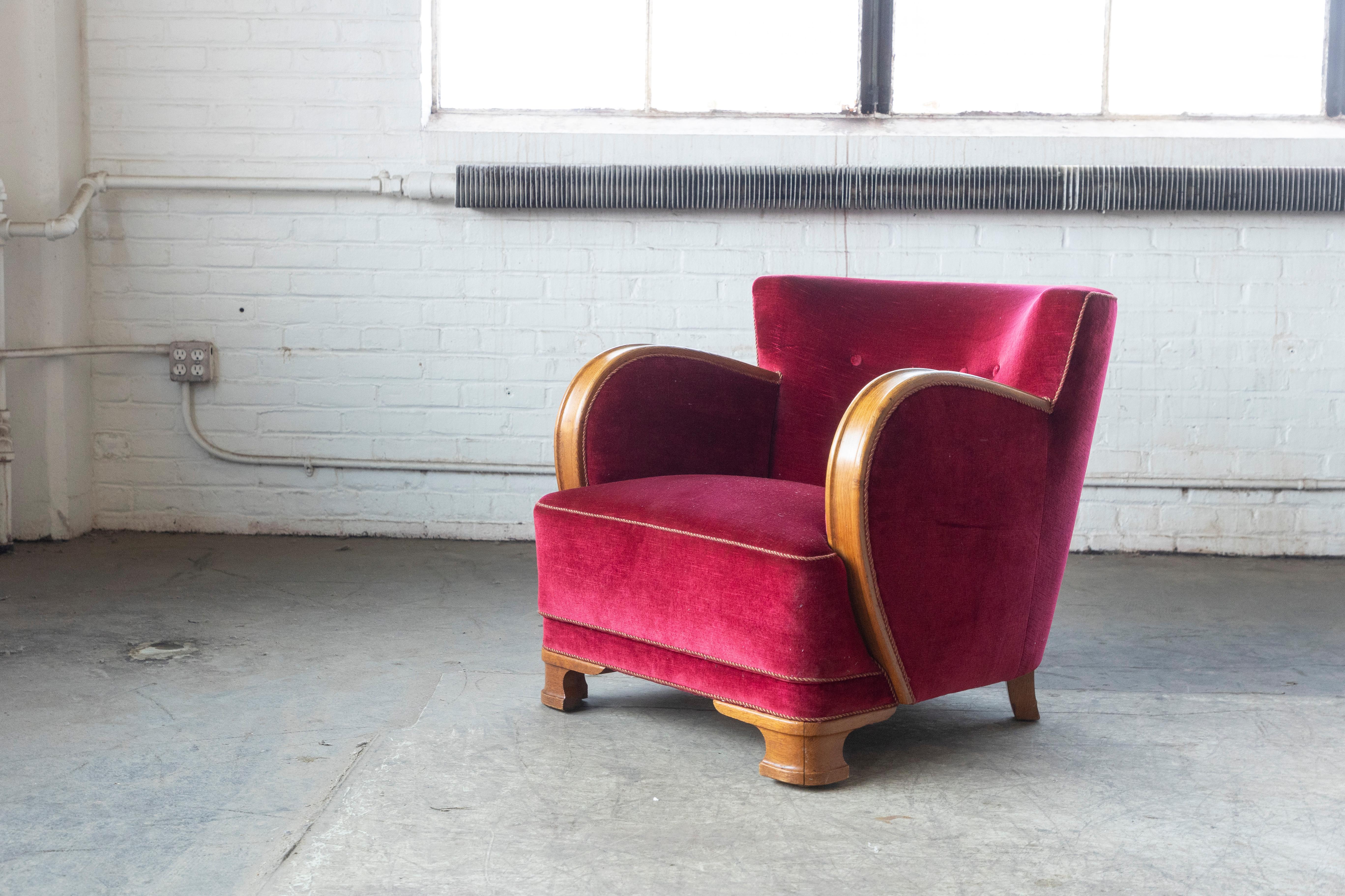 Curvy and eye-catching Danish club chair from the 1930s or 1940s. Set on oak feet typical of the art 
