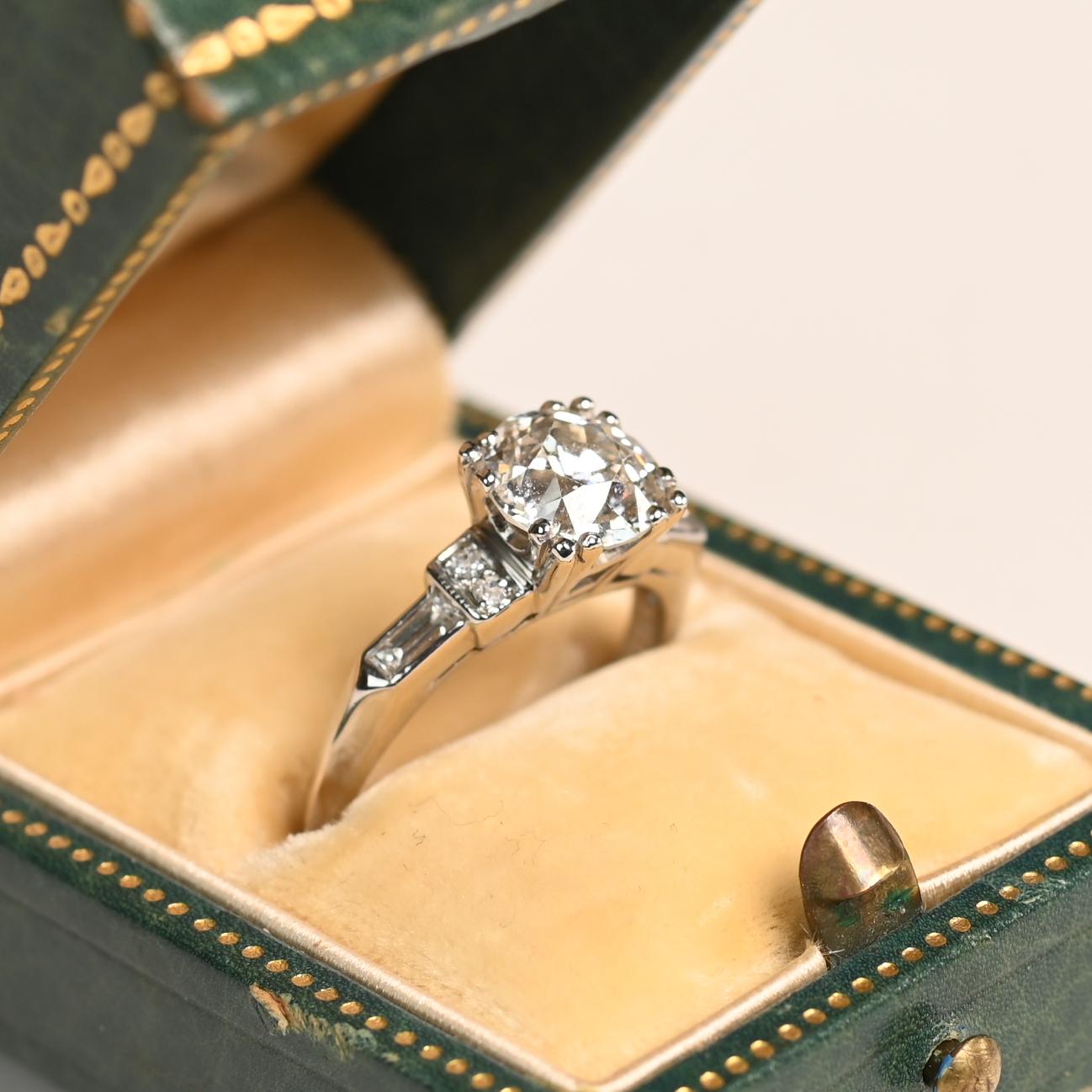 Questo squisito anello in platino Art Deco mette in mostra un impressionante diamante vecchio taglio europeo da 1,60 carati certificato GIA, di colore J e purezza VS1, incastonato in una classica montatura a castone. Le spalle dell'anello sono