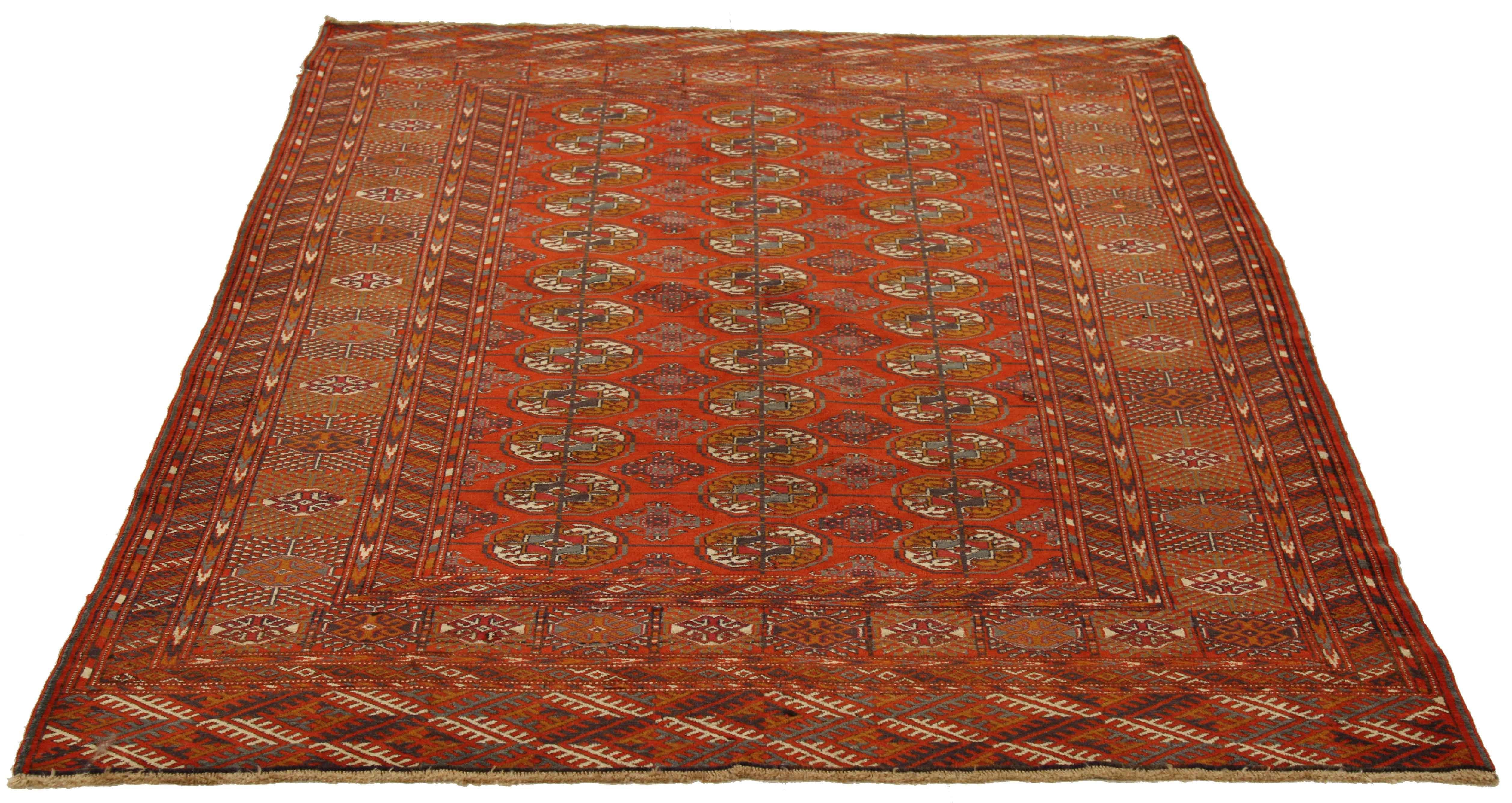 Antique Persian rug handwoven from the finest sheep’s wool and colored with all-natural vegetable dyes that are safe for humans and pets. It’s a traditional Turkmen design featuring round floral medallions in black and ivory over a deep red field.