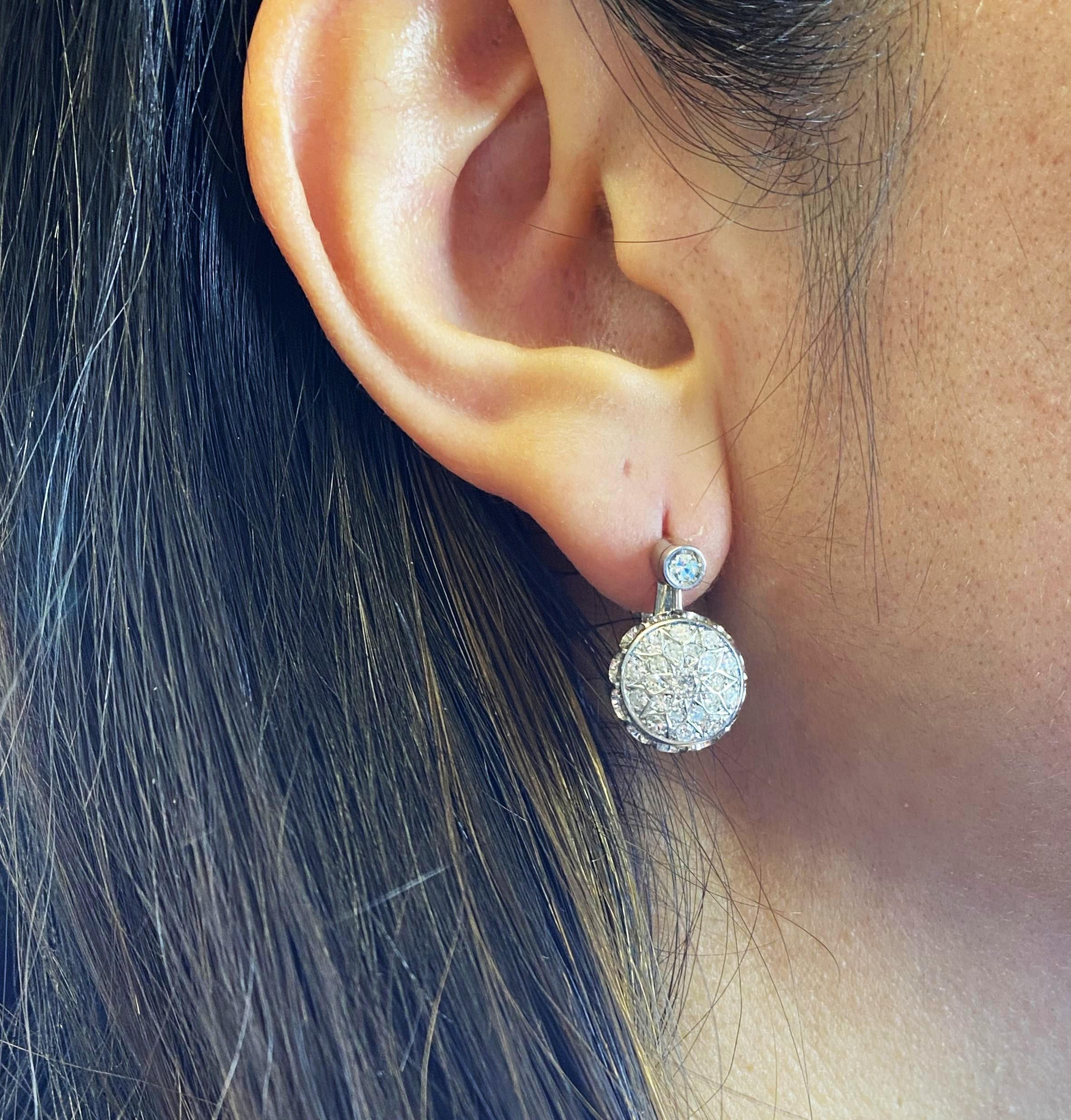 This refined pair of Art Deco drop earrings is expertly crafted in 18kt white gold, featuring a dazzling arrangement of 44 natural diamonds, together weighing approximately 1.00 carat (H color, graded colorless, VS–SI clarity). The elegant geometric