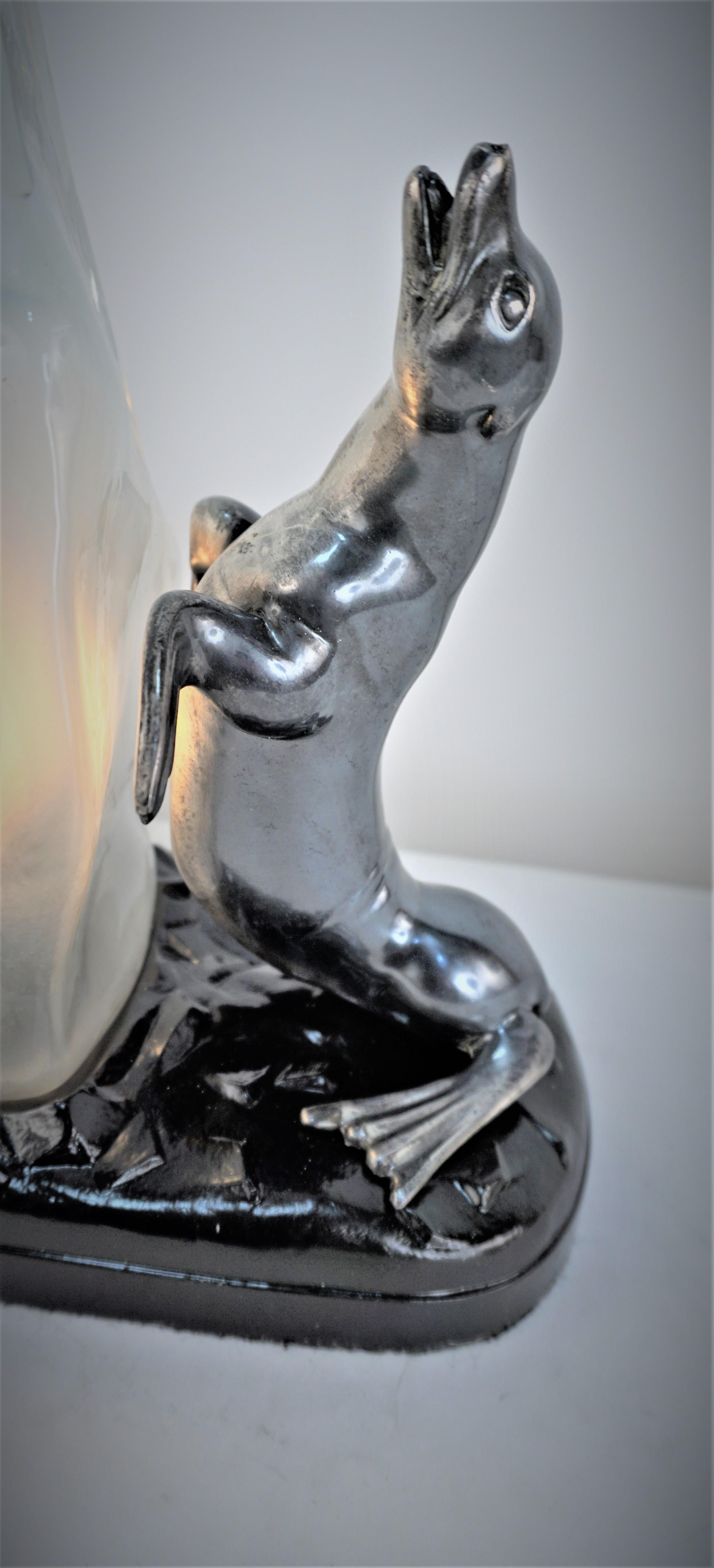 1930's art deco seal table lamp in oxidized silver plate and black lacquered base, molded glass as large piece of ice.