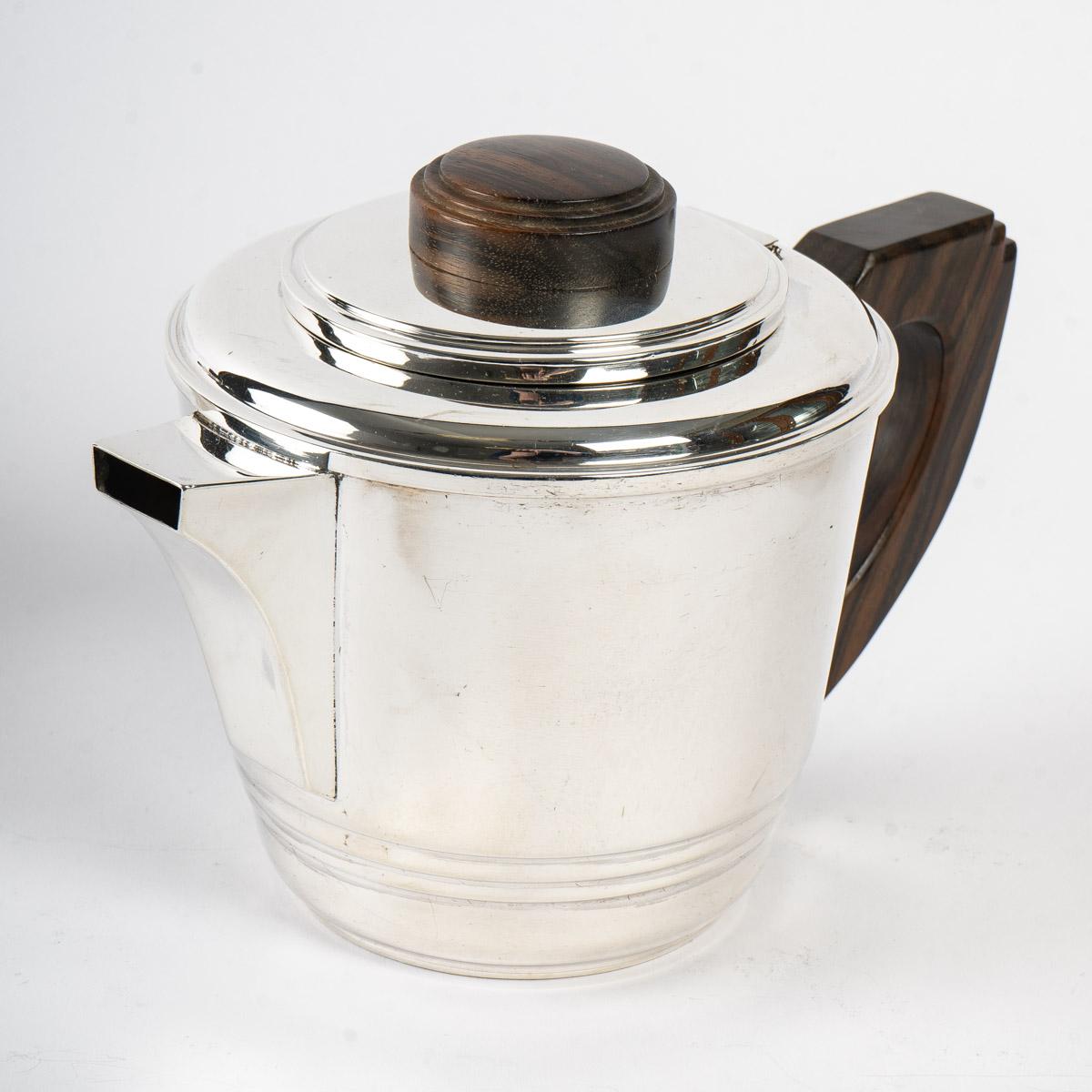 Art Deco tea and coffee set in sterling pure silver and macassar by Jean E. Puiforcat made in the 1930s.

Service including:
- a coffee pot: 15 cm x 22 cm
- a sugar pot: 11 cm x 16 cm
- a milk pot: 7,5 cm x 7,5 cm

Minerve solid silver