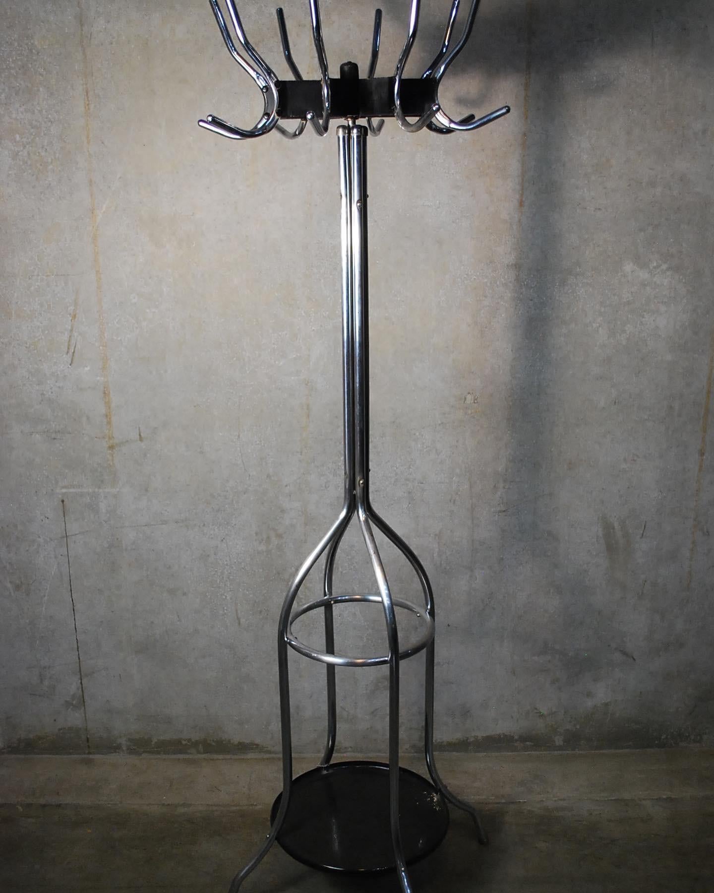 1930's vintage amercian industrial freestanding coat rack with combination umbrella stand, typically found in the barbershop or physician's office.
 Base is comprised of heavy gauge bent tubular steel legs with a riveted joint ring and concealed