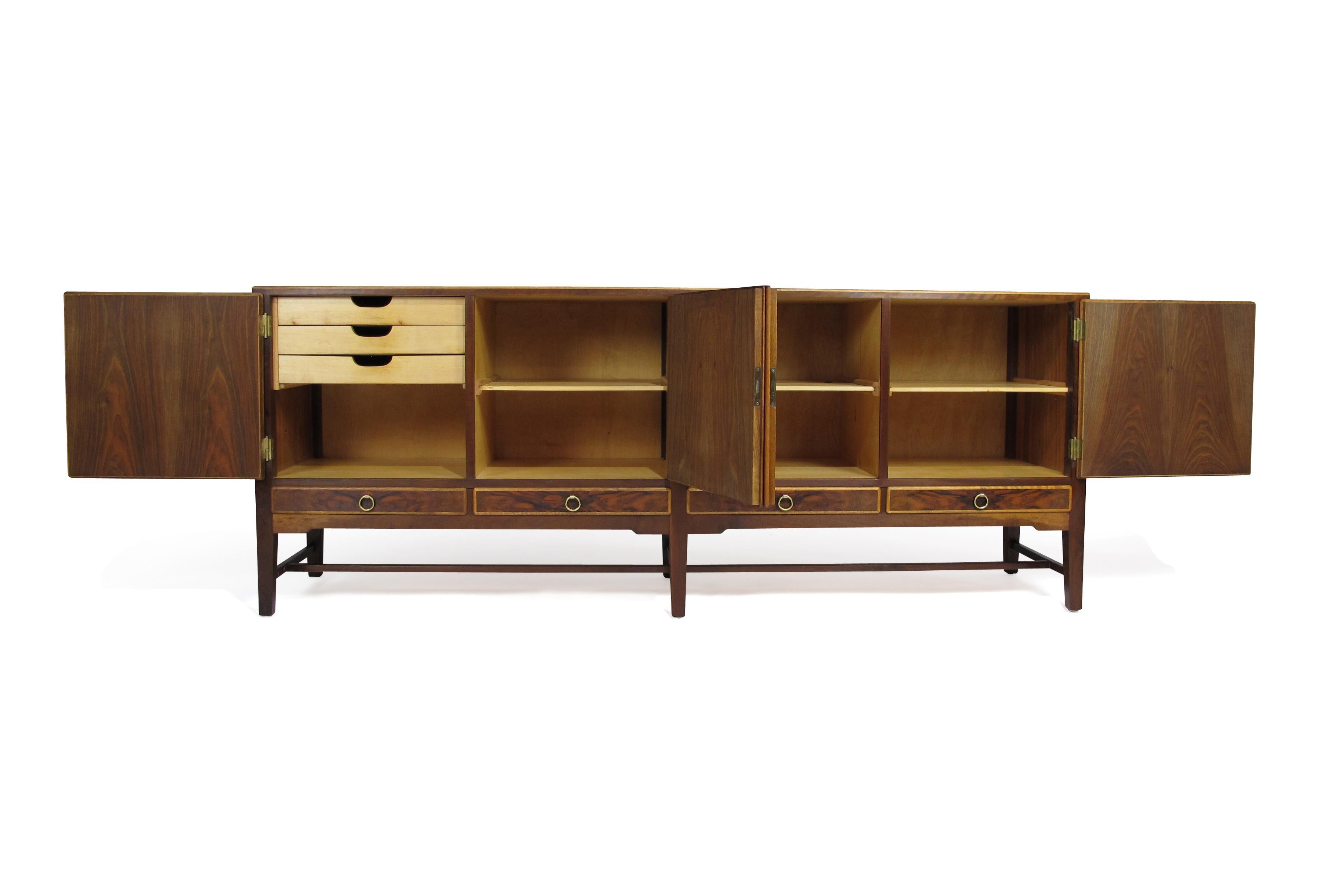 Finely crafted 1930s Scandinavian cabinet of burled walnut with figured book-matched grain, dove tail joinery and series of four locking doors above four drawers with solid brass pulls. The cabinet doors are fully locking and when opened reveal