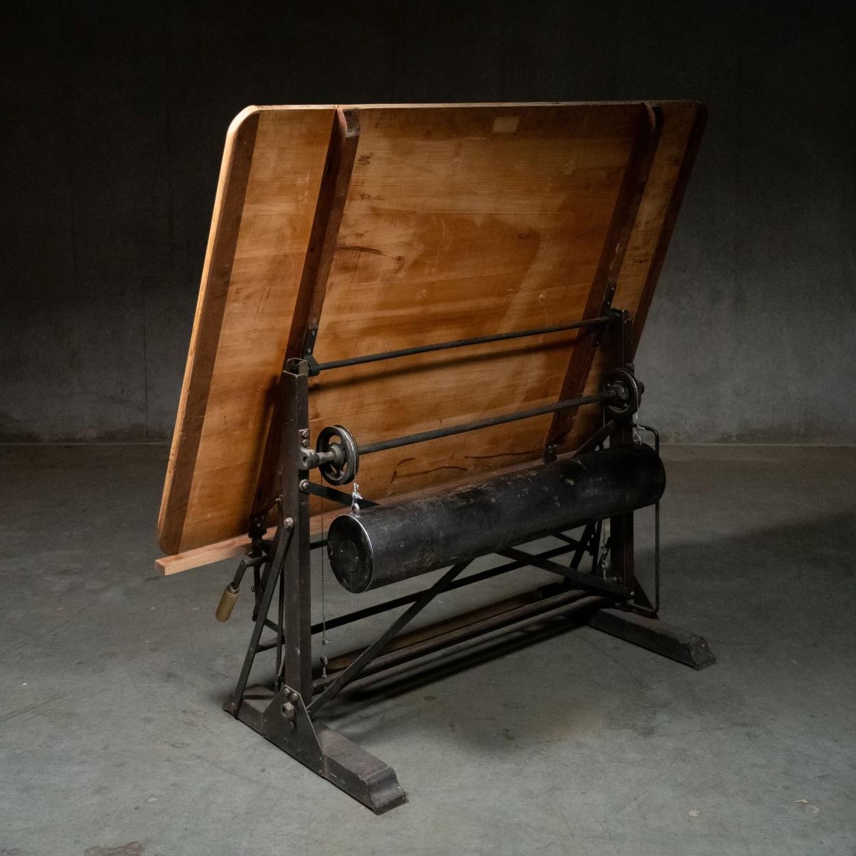 Il s'agit d'une table à dessin en érable entièrement réglable, fabriquée par Kahn Frères de Bruxelles, en Belgique. La plate-forme est entièrement modulaire. La pédale en bois située à l'avant permet d'élever et d'abaisser le plateau et de