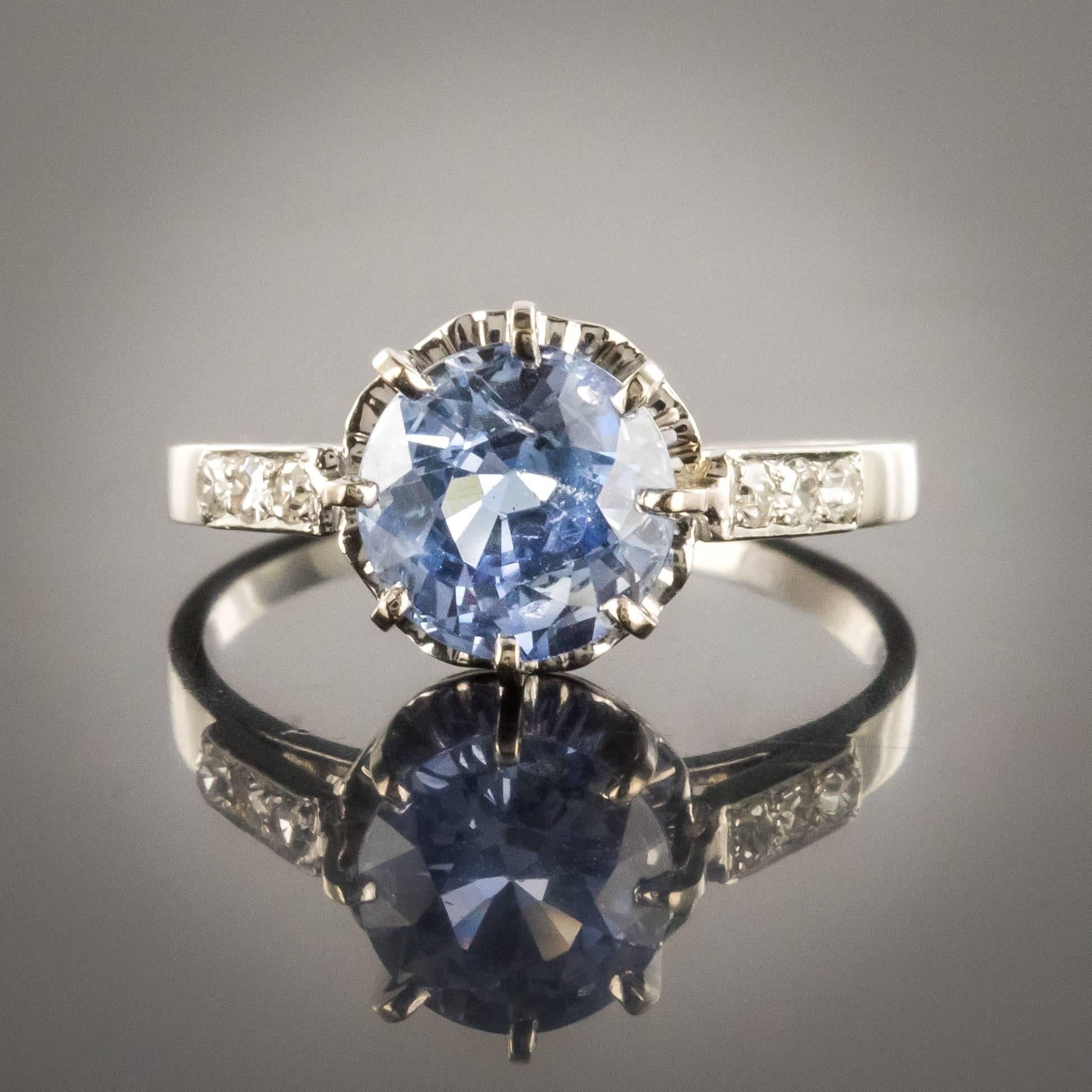 Ring in platinum, dog's head hallmark.
This elegant antique art deco ring is set with claws of a round sapphire crystal clear and limpid. On both sides on the departure of the ring are set 2 x 3 diamonds. The basket is perforated to allow light to