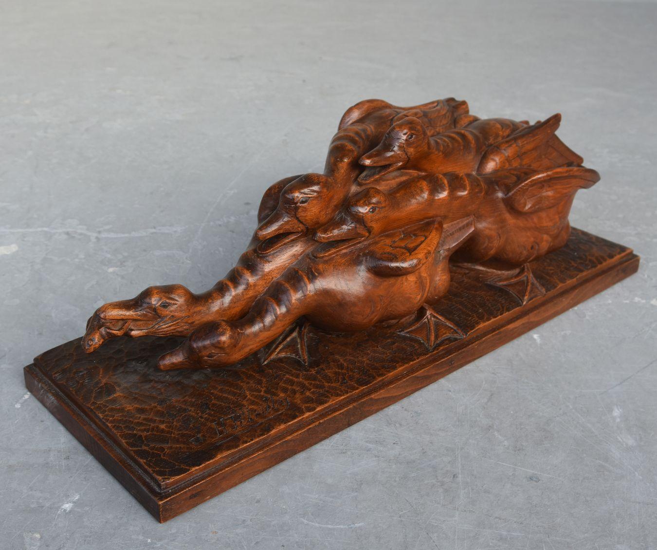 sculpture en bois des années 1930 représentant des oies se disputant une grenouille par H. Petrilly.