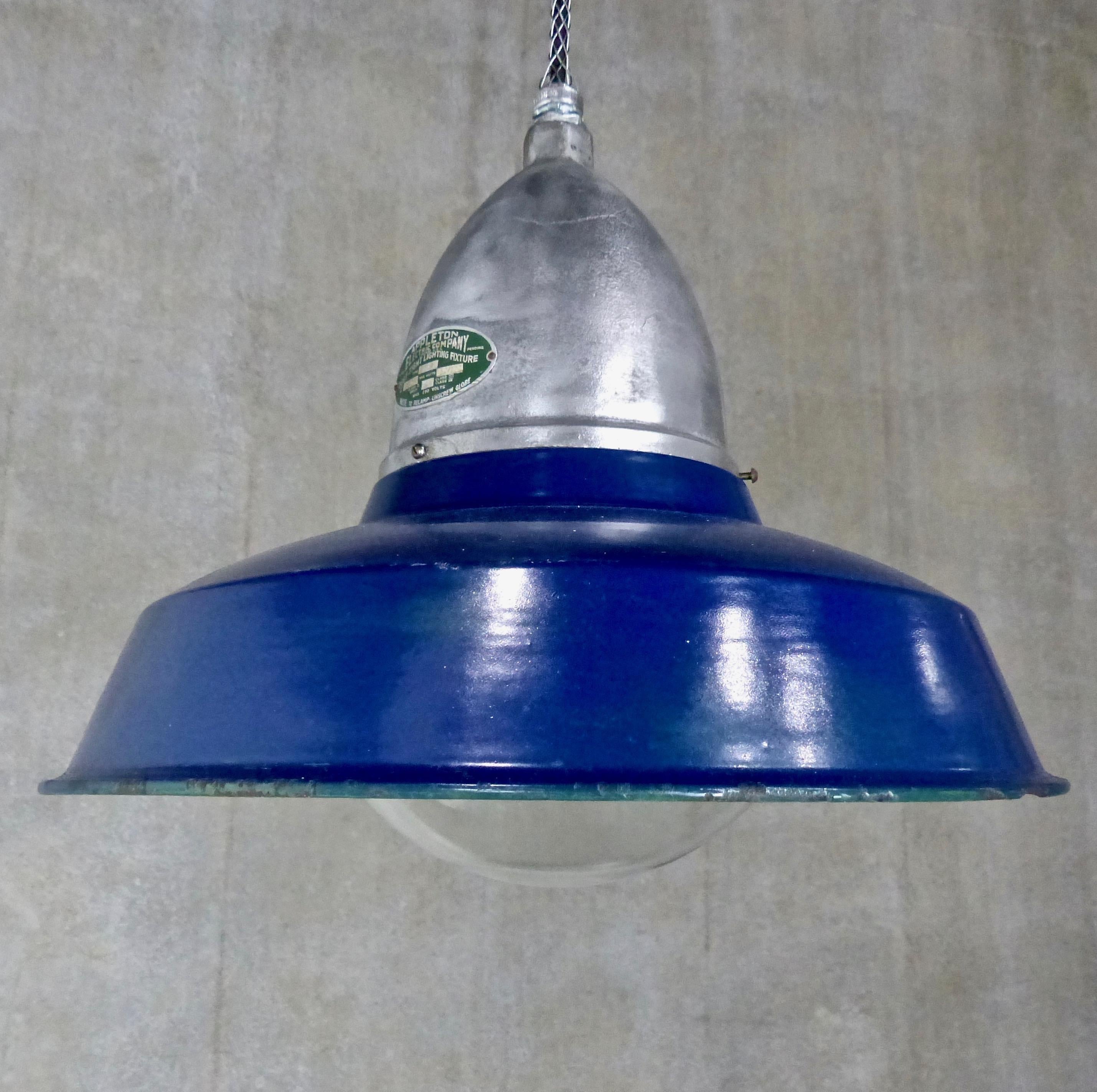 Sought-after Industrial/factory pendant lights with cast metal housings and ‘explosion proof’ glass globes. With rare, original cobalt blue enamel shades. Produced and signed by the Appleton Electric Company, Chicago, IL, circa 1930. Re-wired and