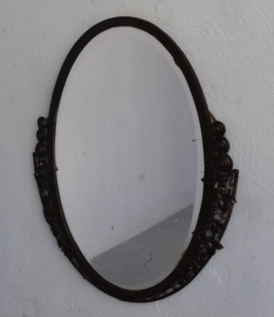 Oval wrought iron mirror Art Deco 1930 beveled glass decoration with ivy leaves. Dimension height 87 cm and a width of 73 cm.
 