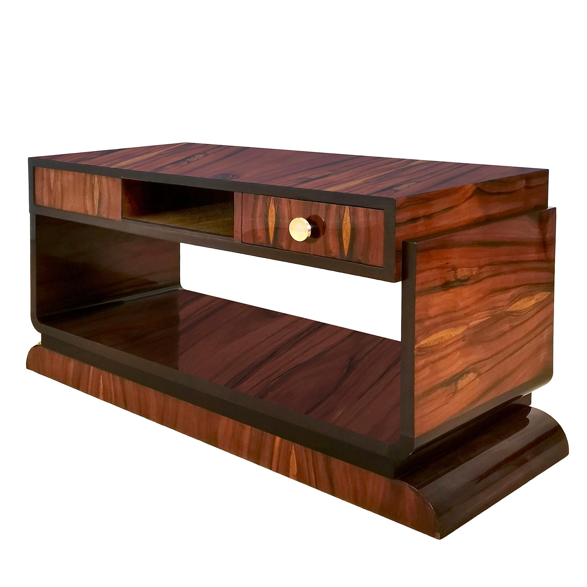 Art Deco coffee table, solid mahogany and spectacular mahogany veneer, one drawer in each frontage, French polish. Polished brass handles.

Design: Jean Fauré (1896-1983)

France, Toulouse, c. 1930

Measures: Top of the table 102 x 43 cm /