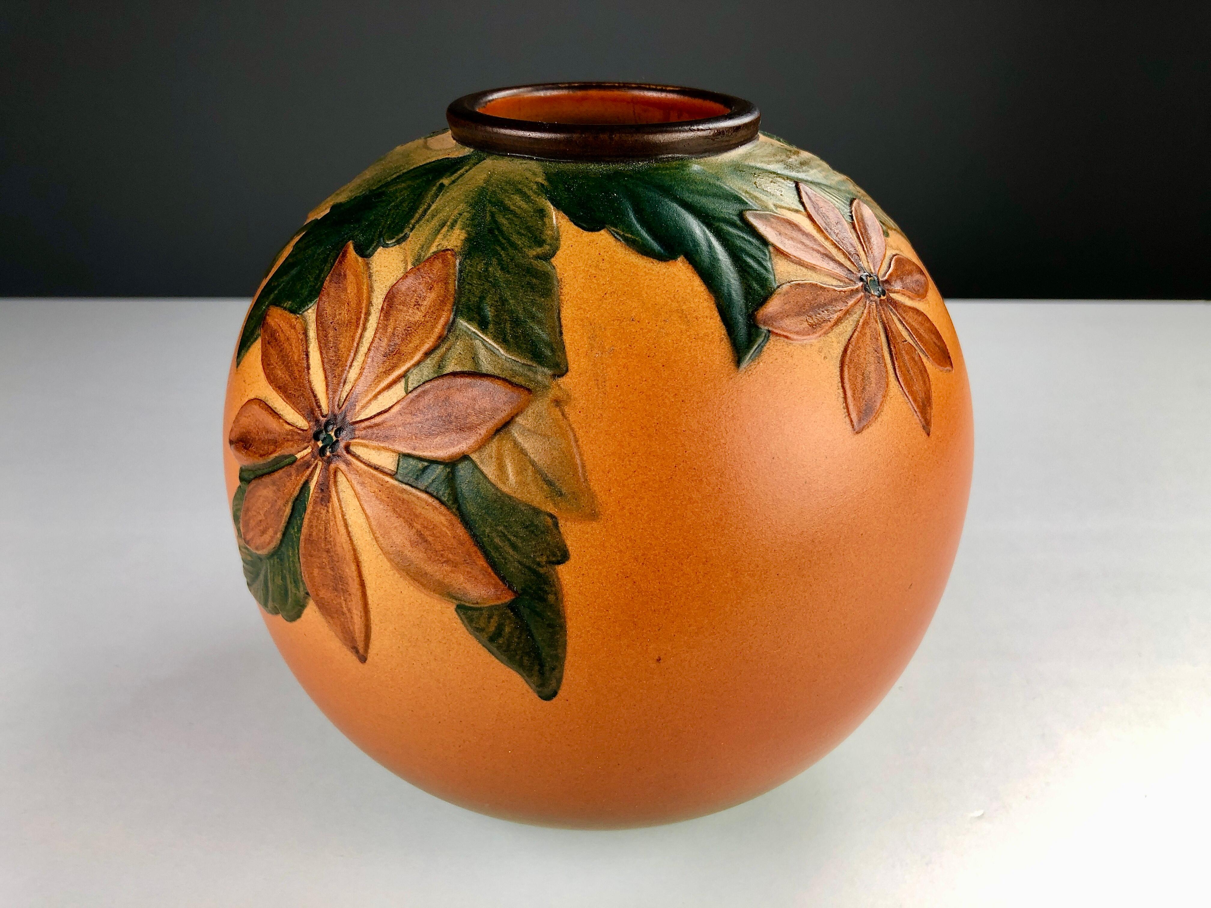 Vase artisanal danois Art nouveau décoré de fleurs par P. Ipsen Enke

Ce vase Art nouveau a été conçu par Axel Sørensen en 1939 et présente des fleurs et des feuilles vivantes très bien réalisées. Les vases ont été fabriqués à la main, d'où de