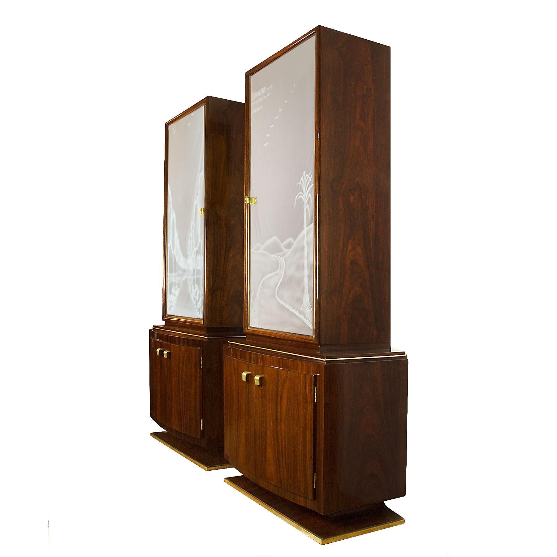 Exceptional pair of Art Deco two blocks cabinets, solid mahogany structure and interiors, mahogany veneer, French polish. Etched mirrors (original oxidation) with brass frame doors. Polished solid brass base, handles and decorative