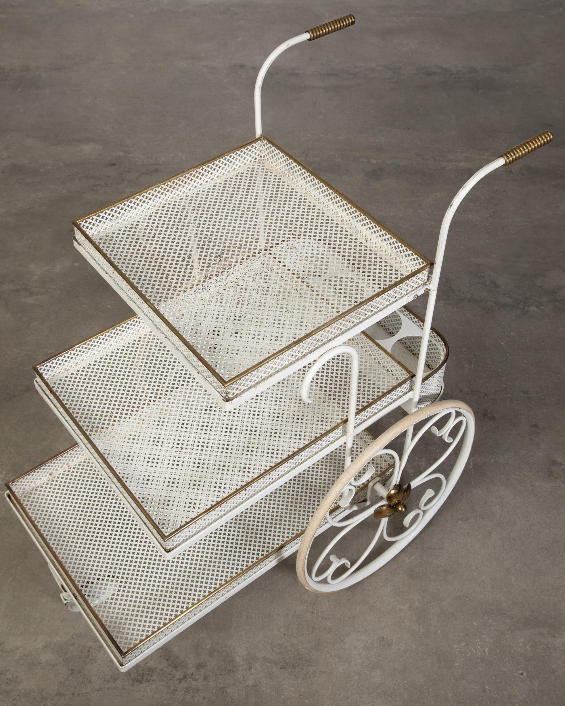 Mid-Century Modern vintage serving and bar cart attributed to Svenskt Tenn and Josef Frank. Late 30´s and made of metal and brass. Three perforated white metal trays that can be lifted out when serving. Beautiful brass details.

Architect,