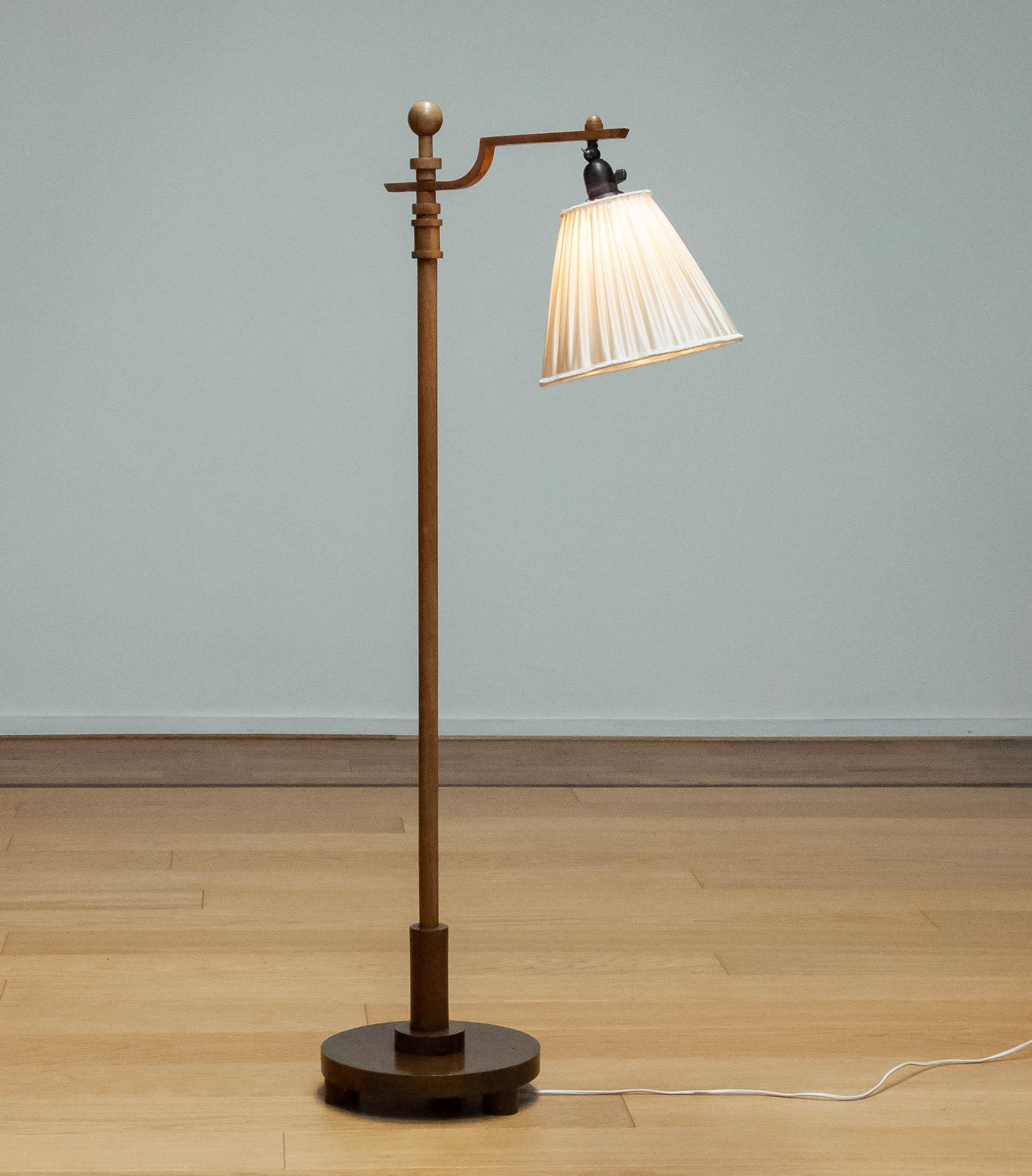Beautiful Swedish designer floor lamp from the Art Deco period 1930s made of walnut. The floor lamp has one screw fitting E27 / E28 and the switch in mounted in the screw fitting. Allover in good condition. 
This beautiful floor lamp is a absolute