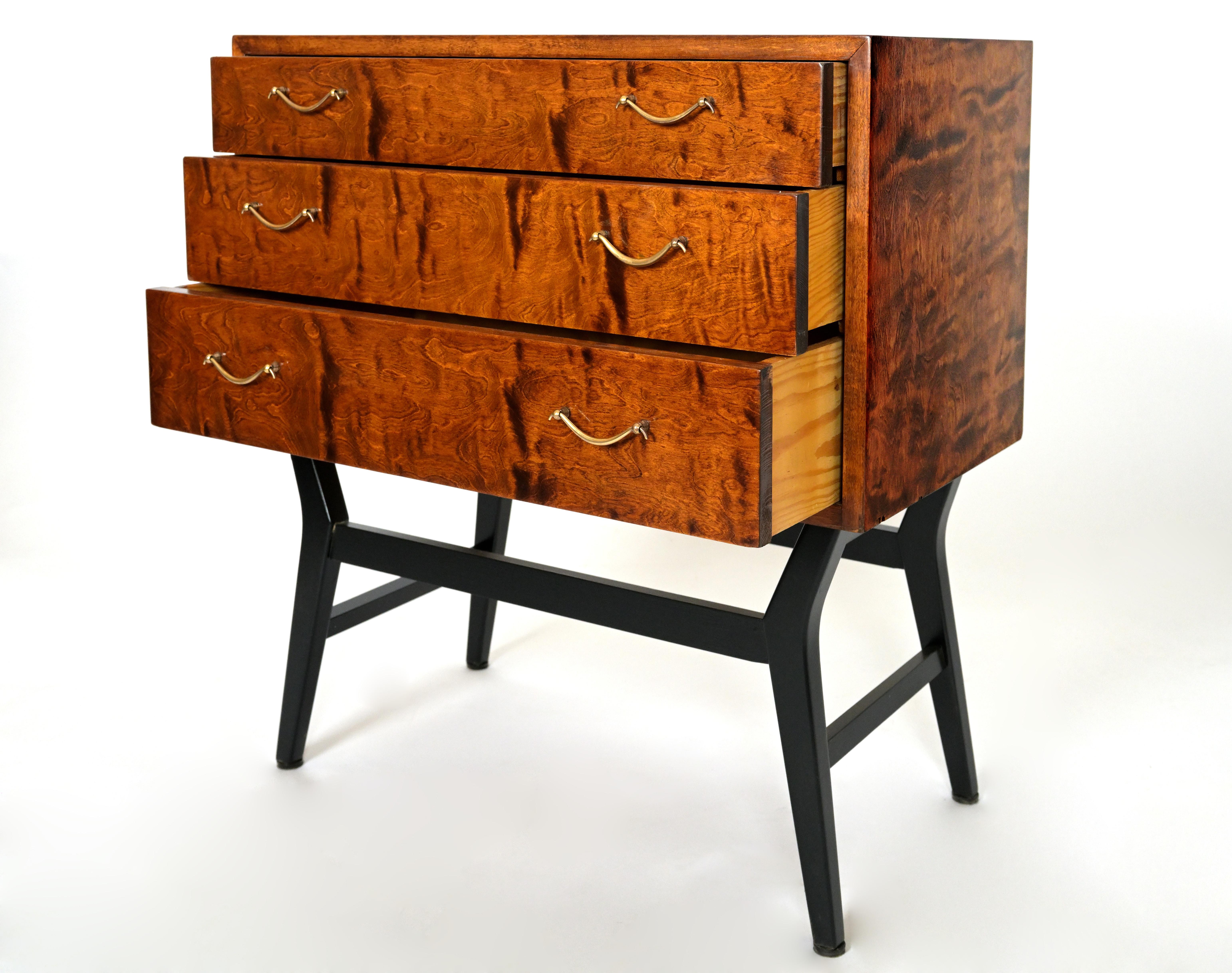 A birch Swedish Grace chest of drawers with  with highly figured birch veneer marbeling on the front, side and three drawers. Each drawer consists of two ring brass handles. The chest is supported by four tethered ebonized base with having side and