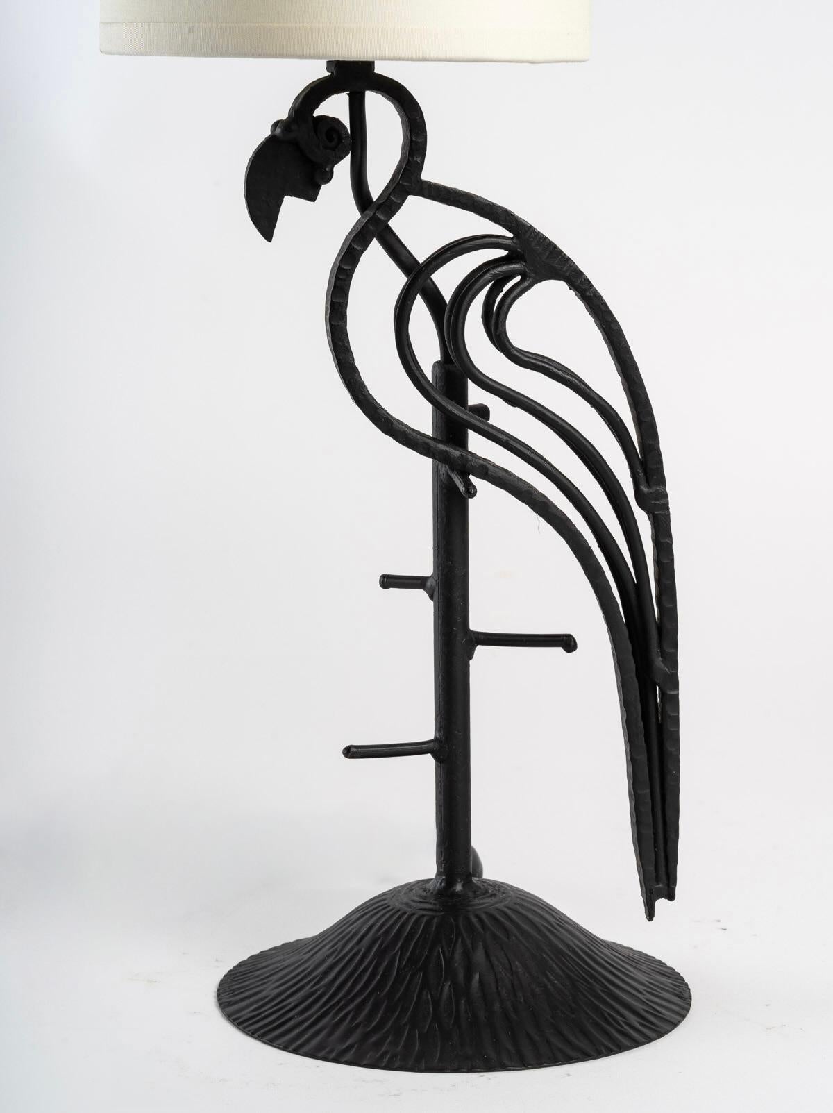 
The lamp rests on a round base in hammered black wrought iron on which is placed a rod like a perch.
On the top of the perch, a parrot is posed, it is made by several fine rods worked by hand in black wrought iron, some are hammered.
The lamp is