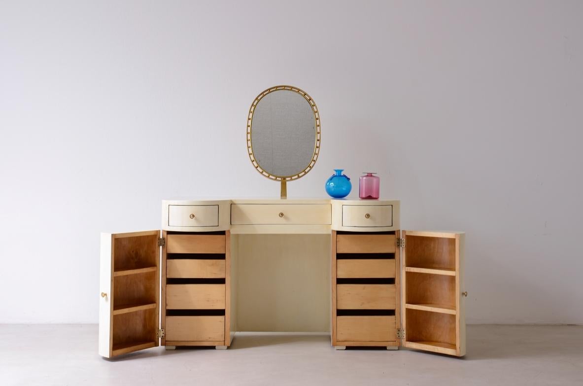 COD-2713
Elegant lacquered wood dressing table/console/desk with tilting brass mirror with classic decorative motif, three drawers and two half-moon compartments with drawers and shelves. Small stool with four turned legs and padded fabric.

Italian