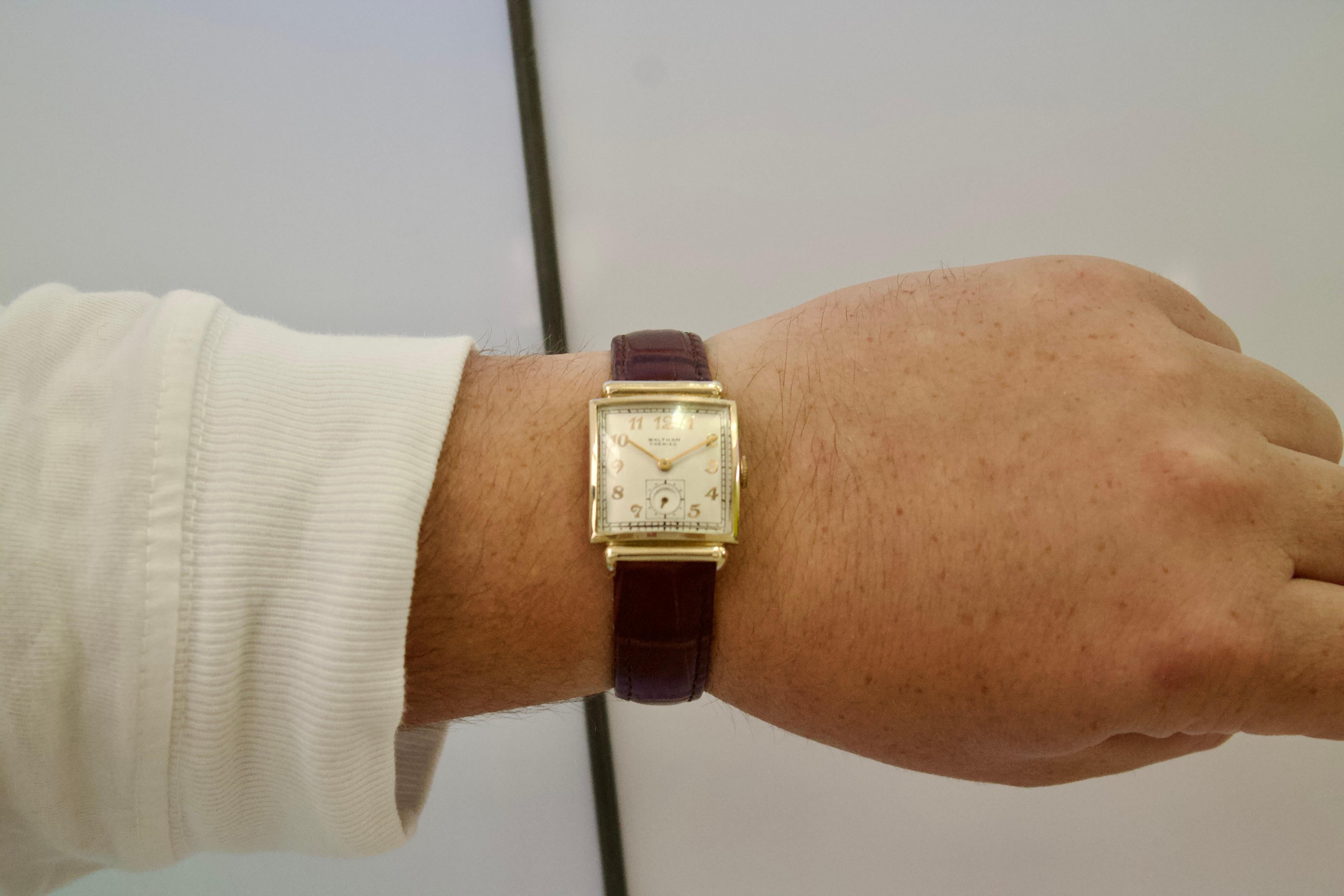 Orologio da polso Waltham Art Deco in oro 14k del 1930 con incisione storica

Questo orologio da polso Waltham degli anni '30, racchiuso in una solida cassa in oro giallo 14 carati, è un pezzo straordinario di storia dell'orologeria e dei