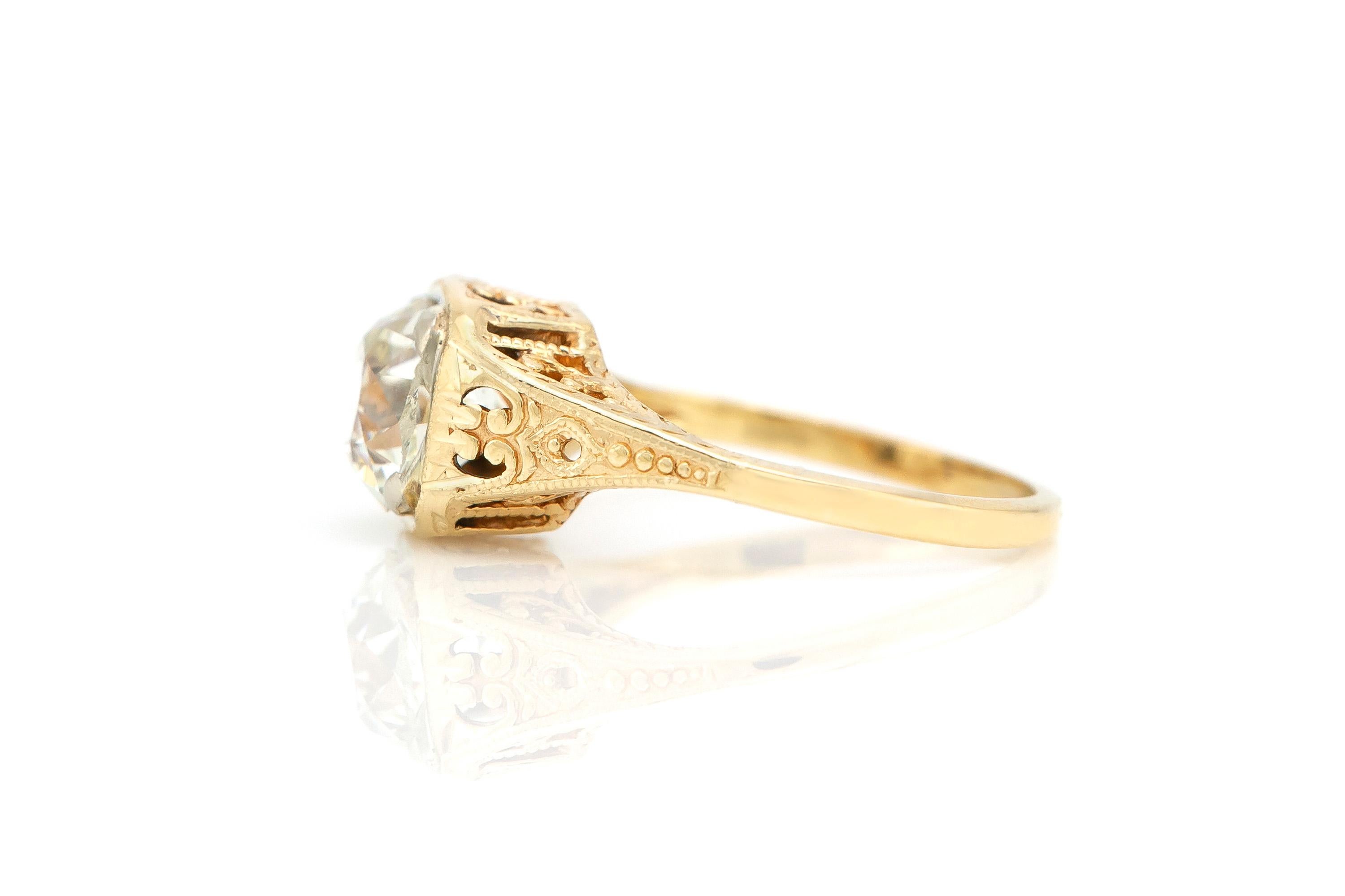 Finely crafted in 14k yellow gold with filligree and a center Old Mine Cushion cut diamond weighing 1.56 carats.
J-K Color, VS2 Clarity
Art Deco, circa 1930s