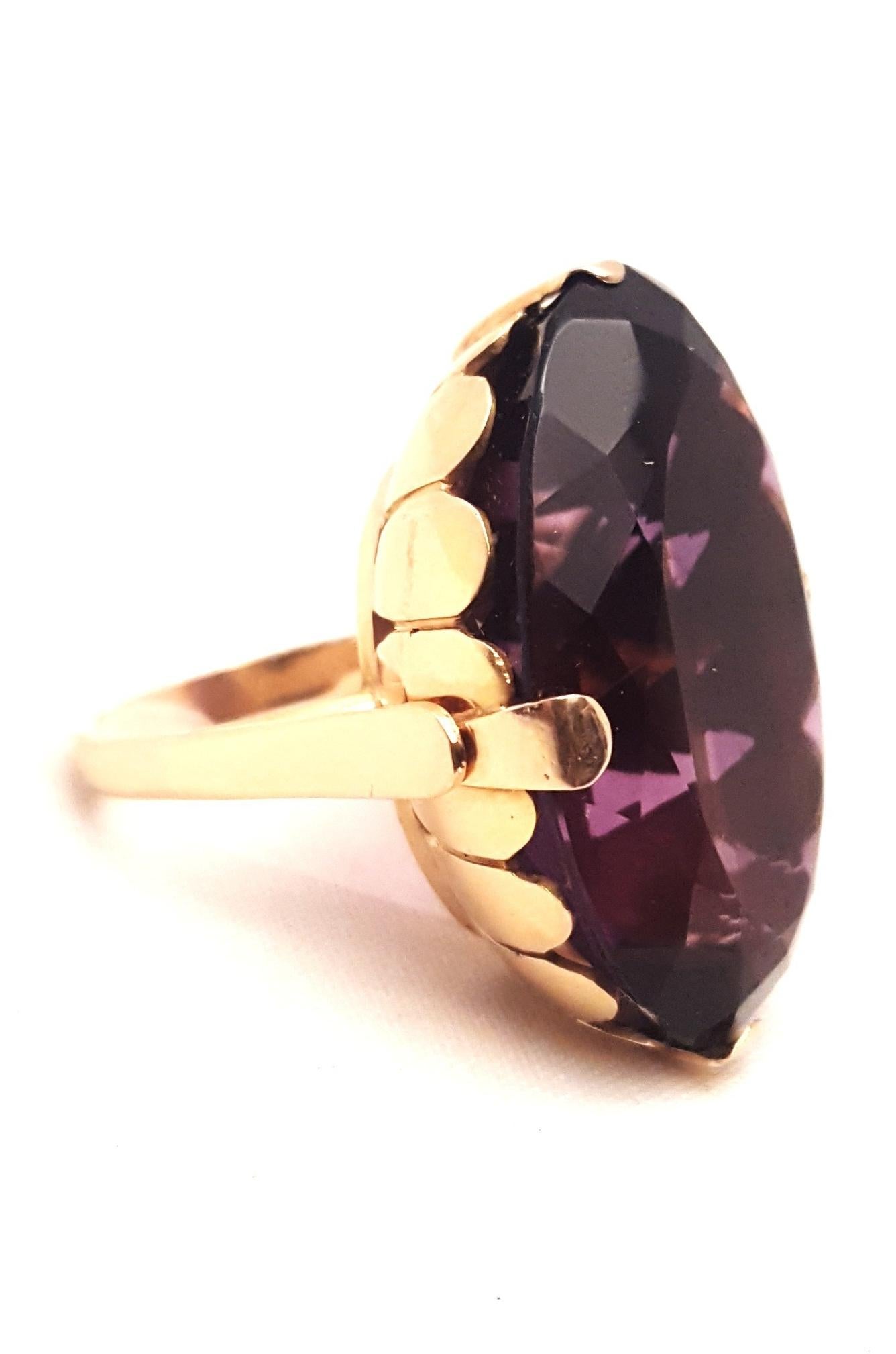 From the 1930's and as current as today!  This statement ring boasts an oval faceted amethyst weighing approximately 70 carats!  Color saturation is deep and even.  Gorgeous amethyst!  Hand fabricated setting in 18 karat yellow gold shows amethyst