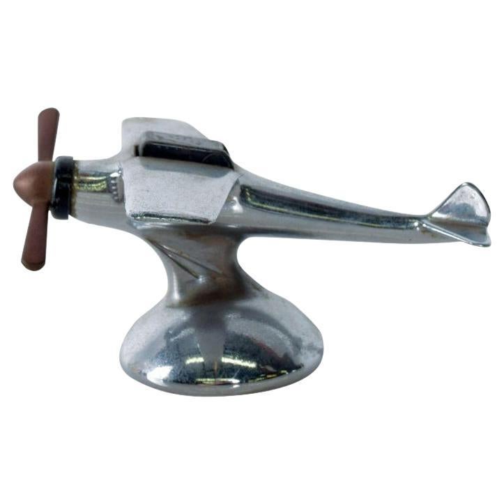 1930s Art Deco airflame chrome airplane table cigarette lighter hatch opens.
Chromed single propeller lighter black cockpit hatch.
Turn the propeller to pop the hatch for use. 
Untested.
Measures: 3 H x 6 L x 5 W inches
Original unrestored