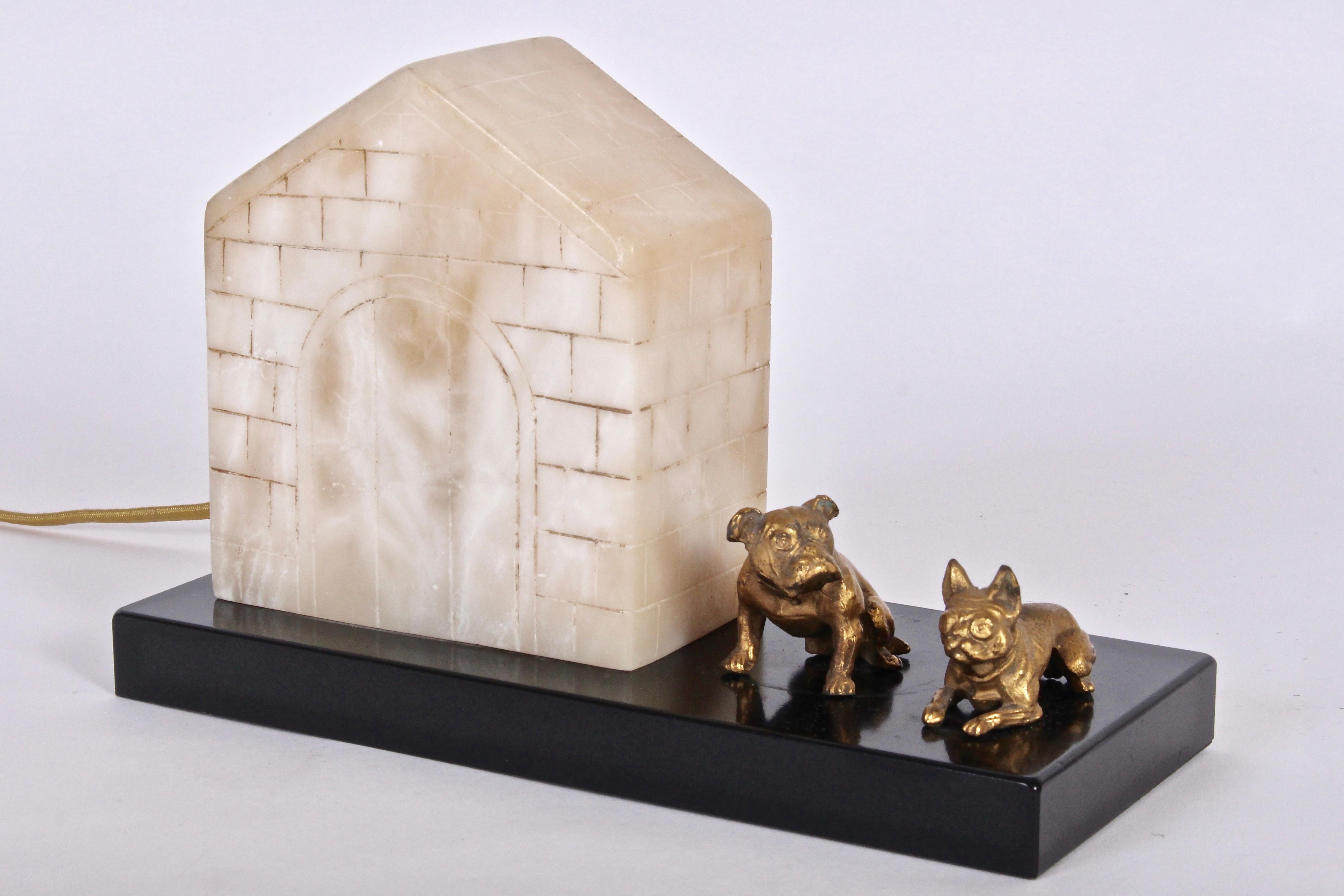 Art Deco Alabaster, Slate and Bronze Dog House Table Lamp with pair of Bull Dogs. Featuring a rectangular black lacquered slate surface, hand incised alabaster brick dog house, with a French Bull Dog and English Bull Dog in cast bronze finish.