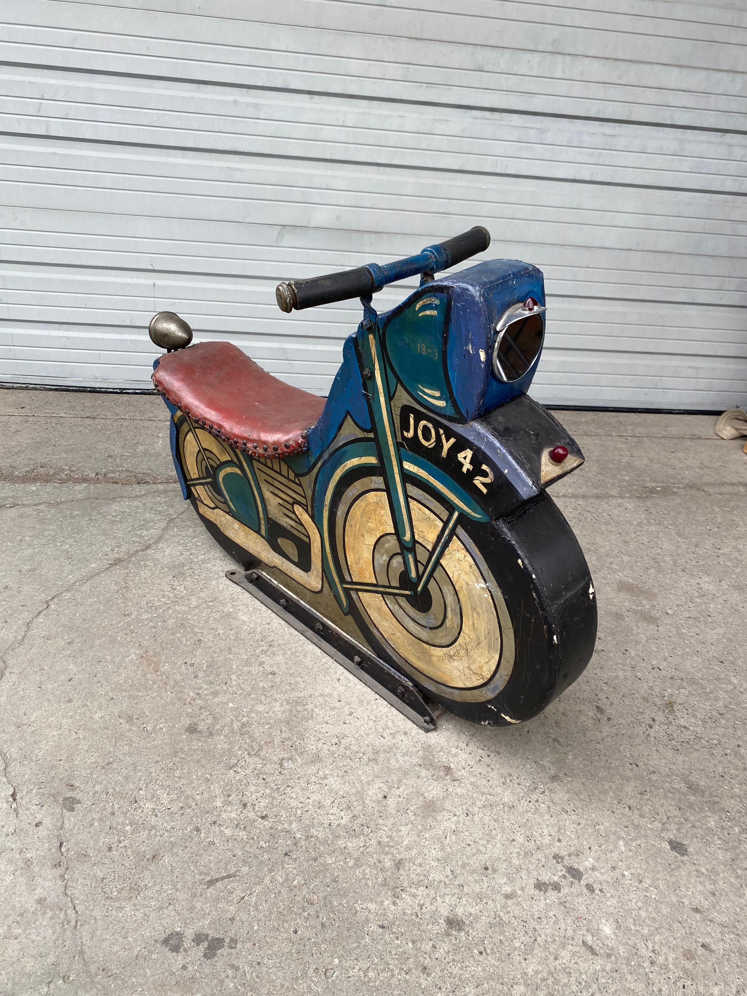1930s Antique midway amusement park wooden motorcycle ride is one of the earliest produced for carousels and merry-go-rounds. Wonderful aged patina, two sided, original paint. Leather padded seat.metal handle bars on a cast iron base, hand delivery