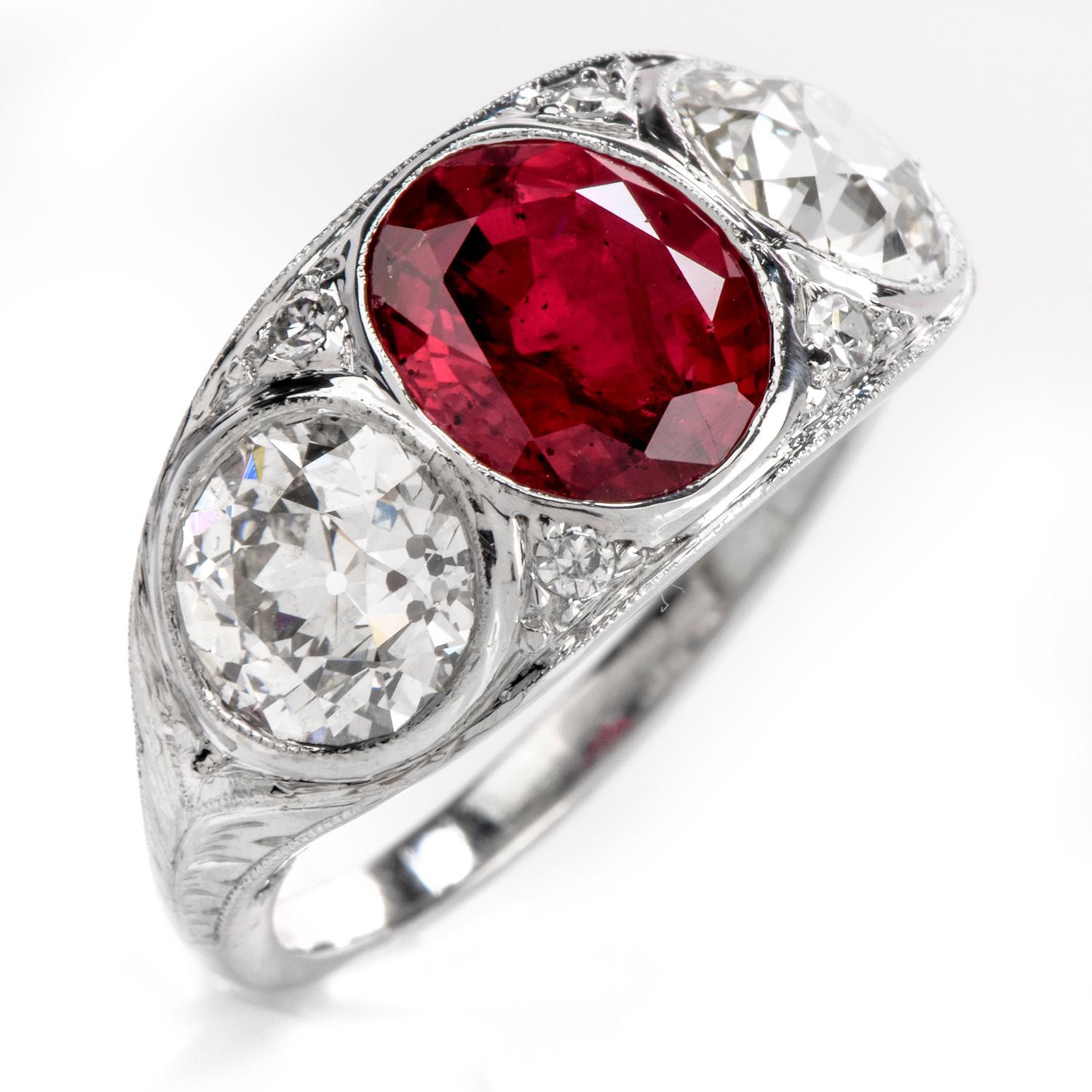 his classic Antique Deco three stone ring crafted in platinum is centered with one lavish GIA certified Natural oval brilliant cut red ruby (heat treated). The nice red natural corundum is flanked on each side with 2 Old European cut diamonds and