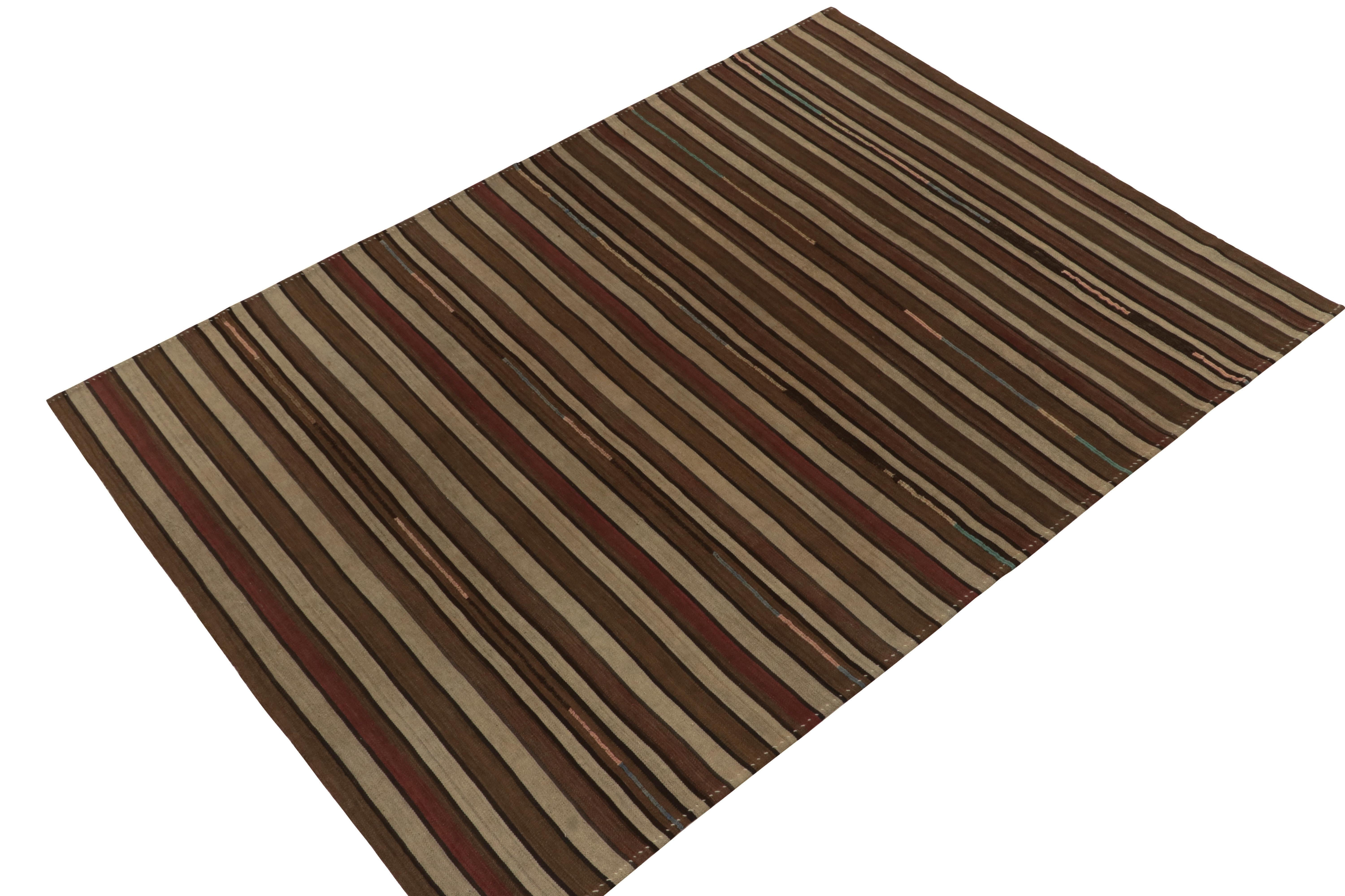 Originating from Turkey circa 1930-1940, a 7x9 antique Kilim carrying simple but subtly playful stripes. Enjoying beige-brown with deep red notes, the piece exemplifies the rustic & simplified approach of tribal aesthetics. Prevailing in good