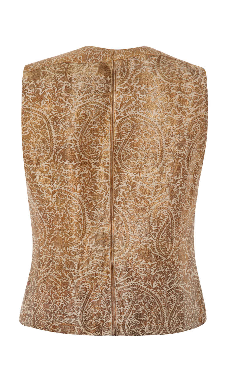 This exquisite 1930s antique ivory silk Indian waistcoat with gold metallic brocade is in lovely vintage condition for a piece of this era and would look fantastic paired with a blouse and jeans. It features an intricate brocade paisley design that