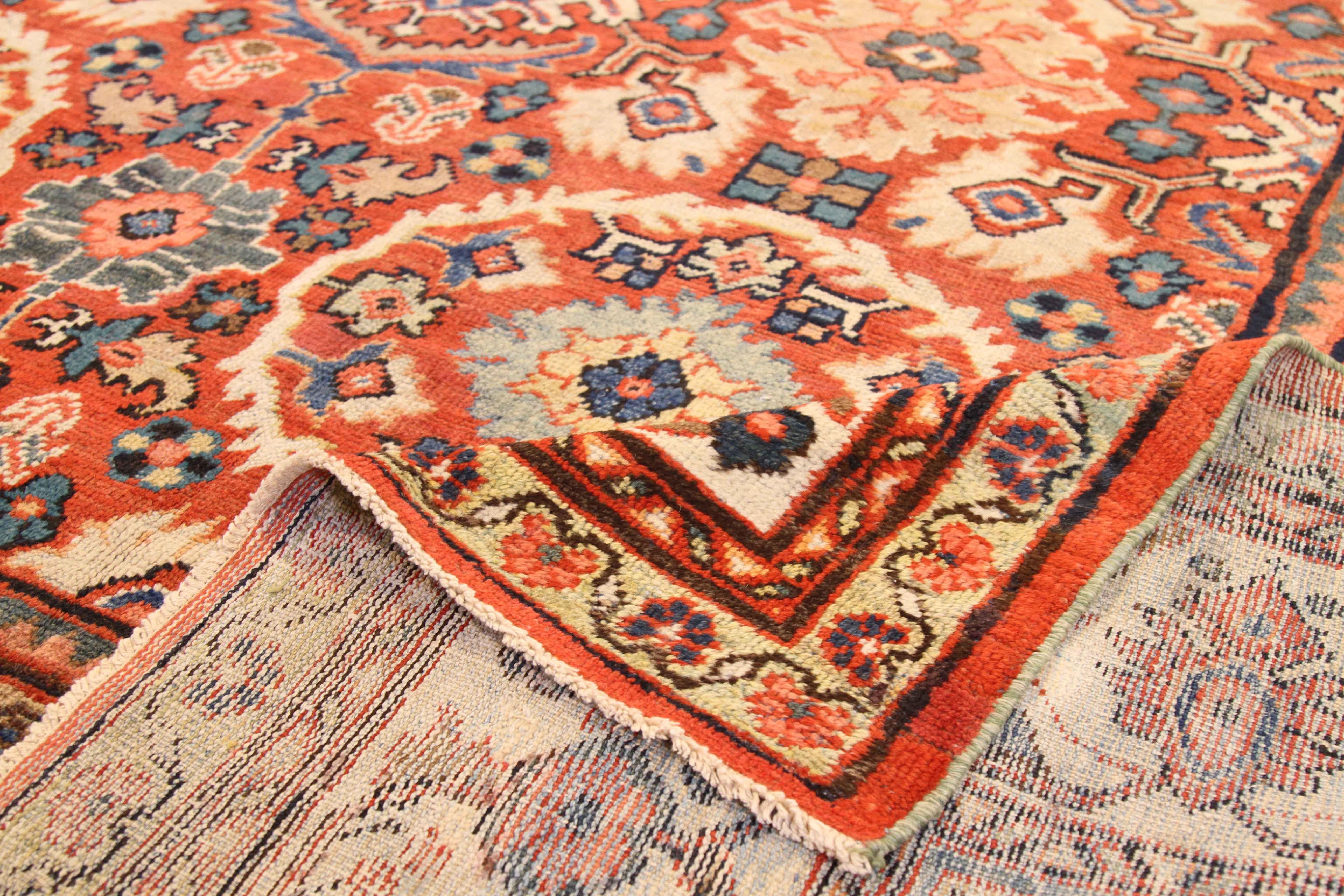 Antique Persian rug hand knotted in the 1930s using the highest quality of wool and plant-based dyes. It showcases a series of oval shaped floral details that are typical of the Sultanabad rug design. For its color, weavers matched cozy ivory with