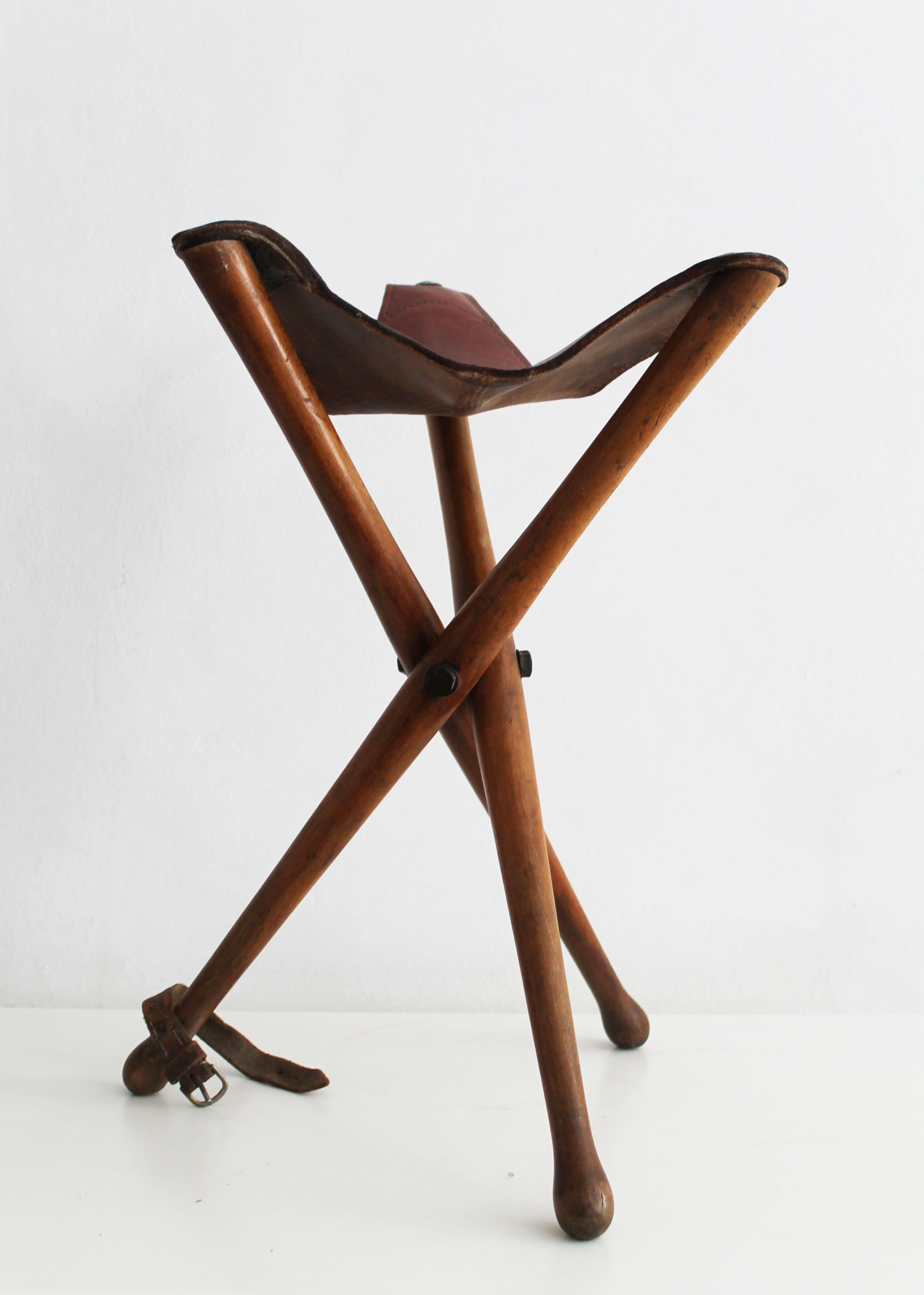 This is an original Antique portable tripod stool with leather seat. This piece is believed to be produced in Austria in the 1930’s.

It is the perfect companion on a day of exploring the sights as a tourist, or on a hunting expedition which is what