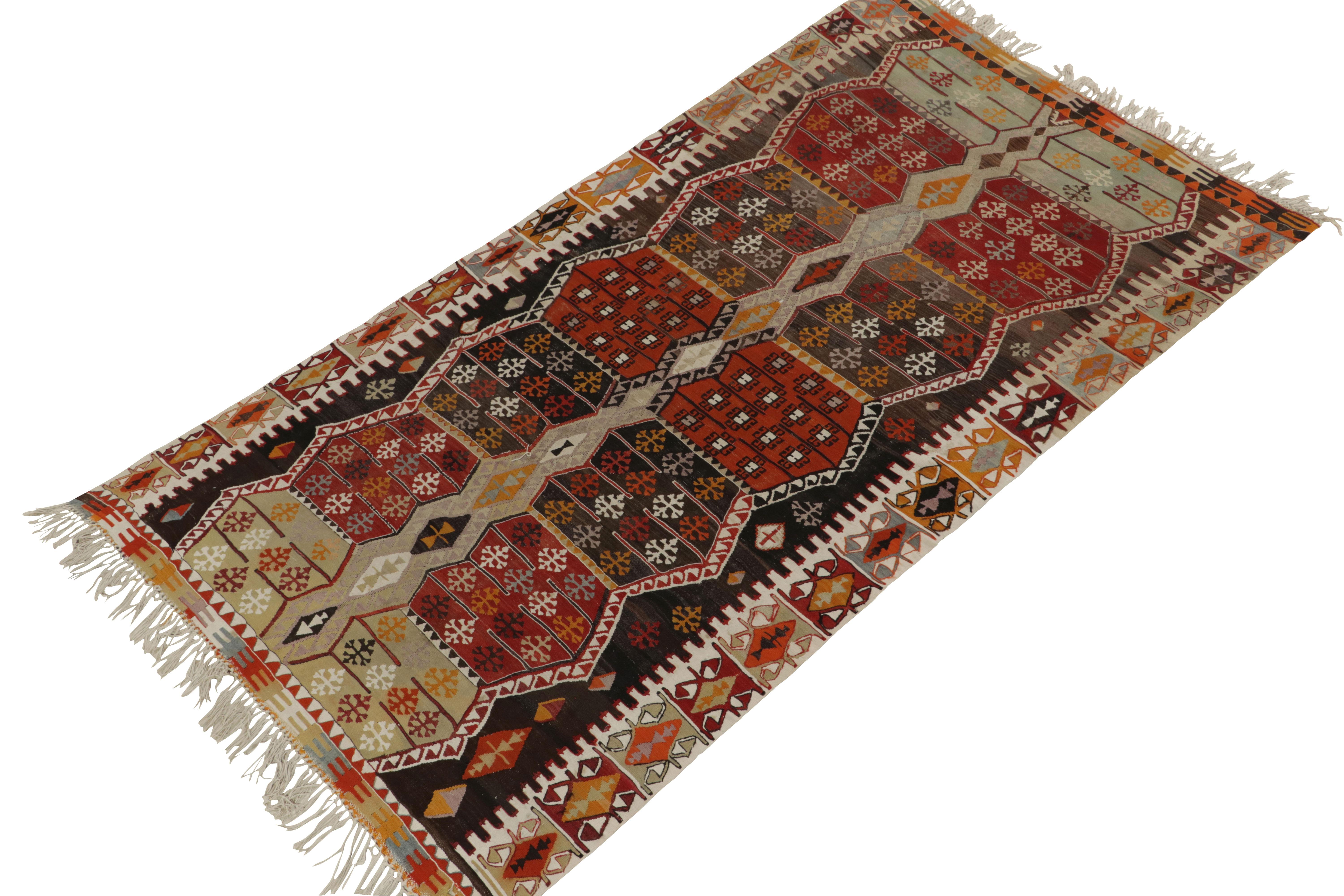 Originating from Turkey circa 1930-1940, a handwoven antique kilim rug enjoying a tribal pattern work. The piece carries a vivacious personality with a bright colorplay of gold-orange, red & gray against beige-brown—a marriage of both traditional
