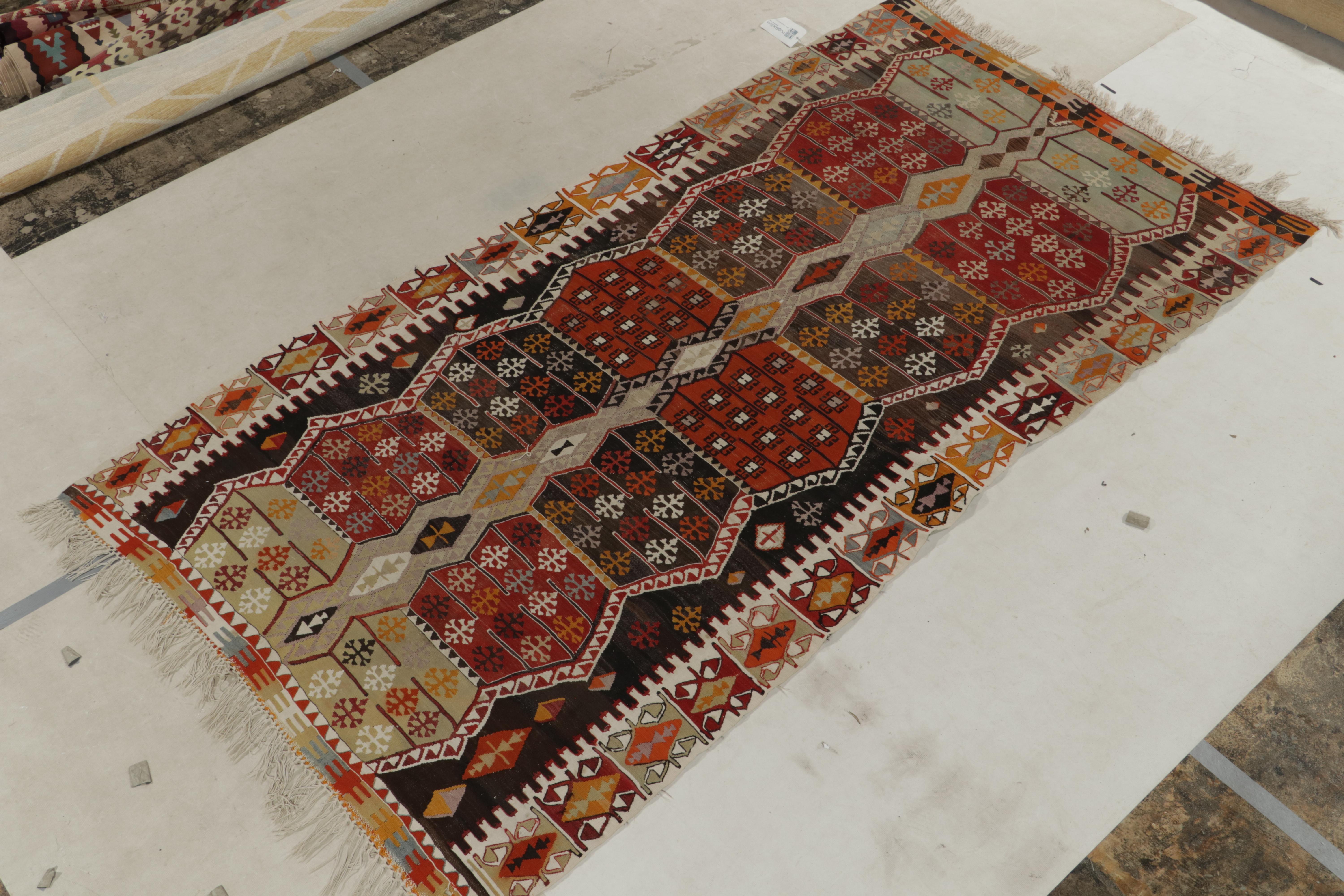 Dieser handgewebte, antike Kelimteppich mit Stammesmuster stammt aus der Türkei (ca. 1930-1940). Das Stück hat eine lebhafte Persönlichkeit mit einem leuchtenden Farbspiel aus Gold-Orange, Rot und Grau auf Beige-Braun - eine Verbindung von