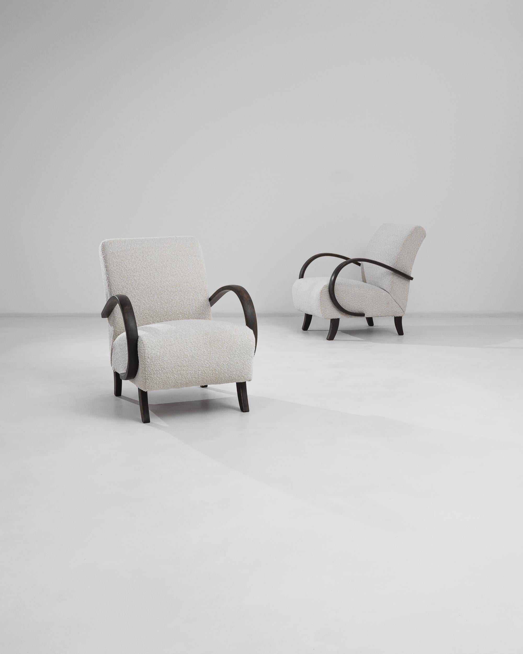 A pair of armchairs by Czech furniture designer J. Halabala. Made in the 1930s, the design was produced in Central European furniture factories throughout the mid-20th Century. The eye-catching silhouette and comfortable shape has had an enduring
