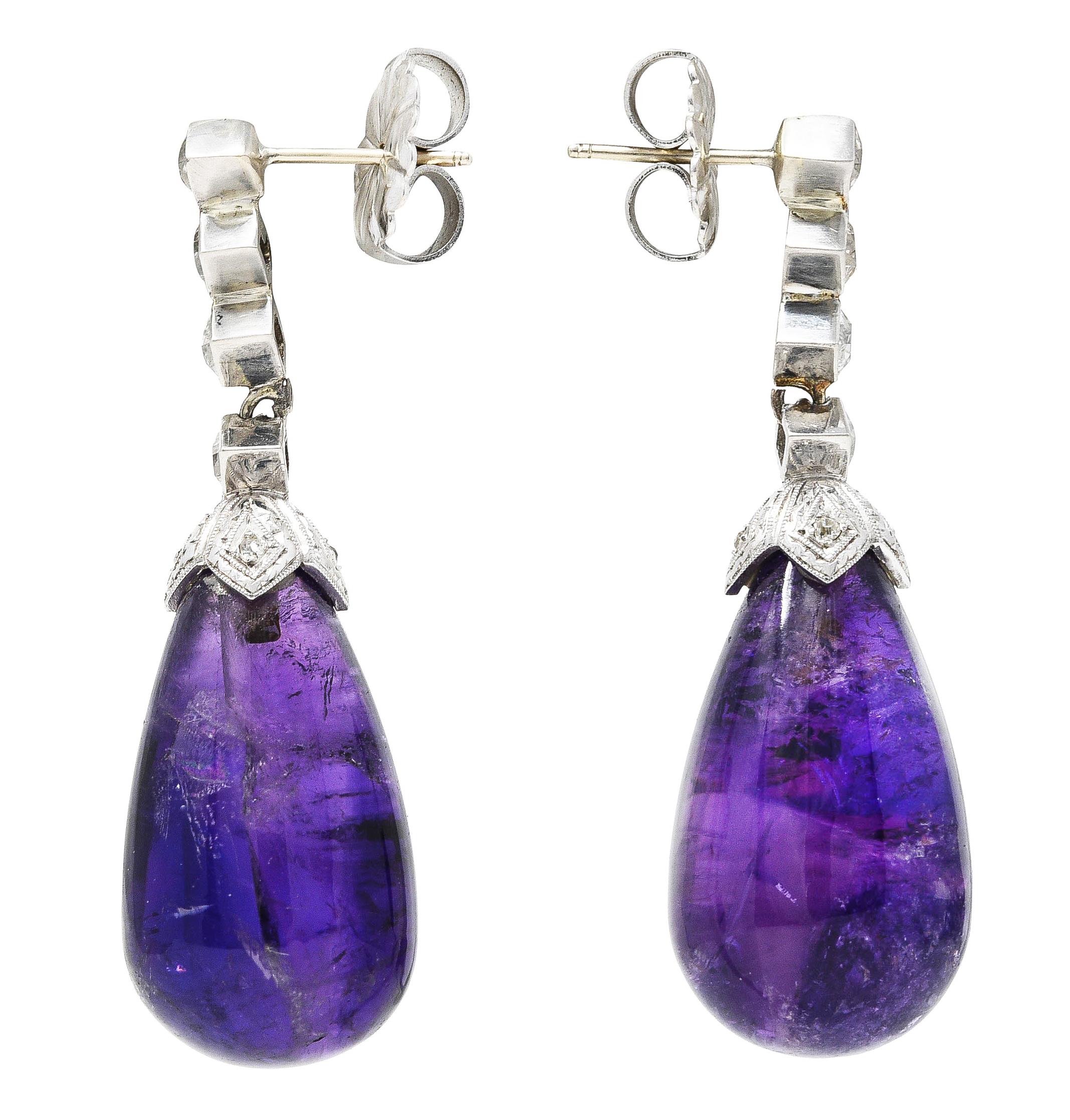 Earring surmounts are designed as hand fabricated navette forms. Kite set with French cut diamonds with G/H color and VS2 to SI1 clarity. Suspending substantial amethyst pampel drops. Well matched in rich purple color and semi-transparent with