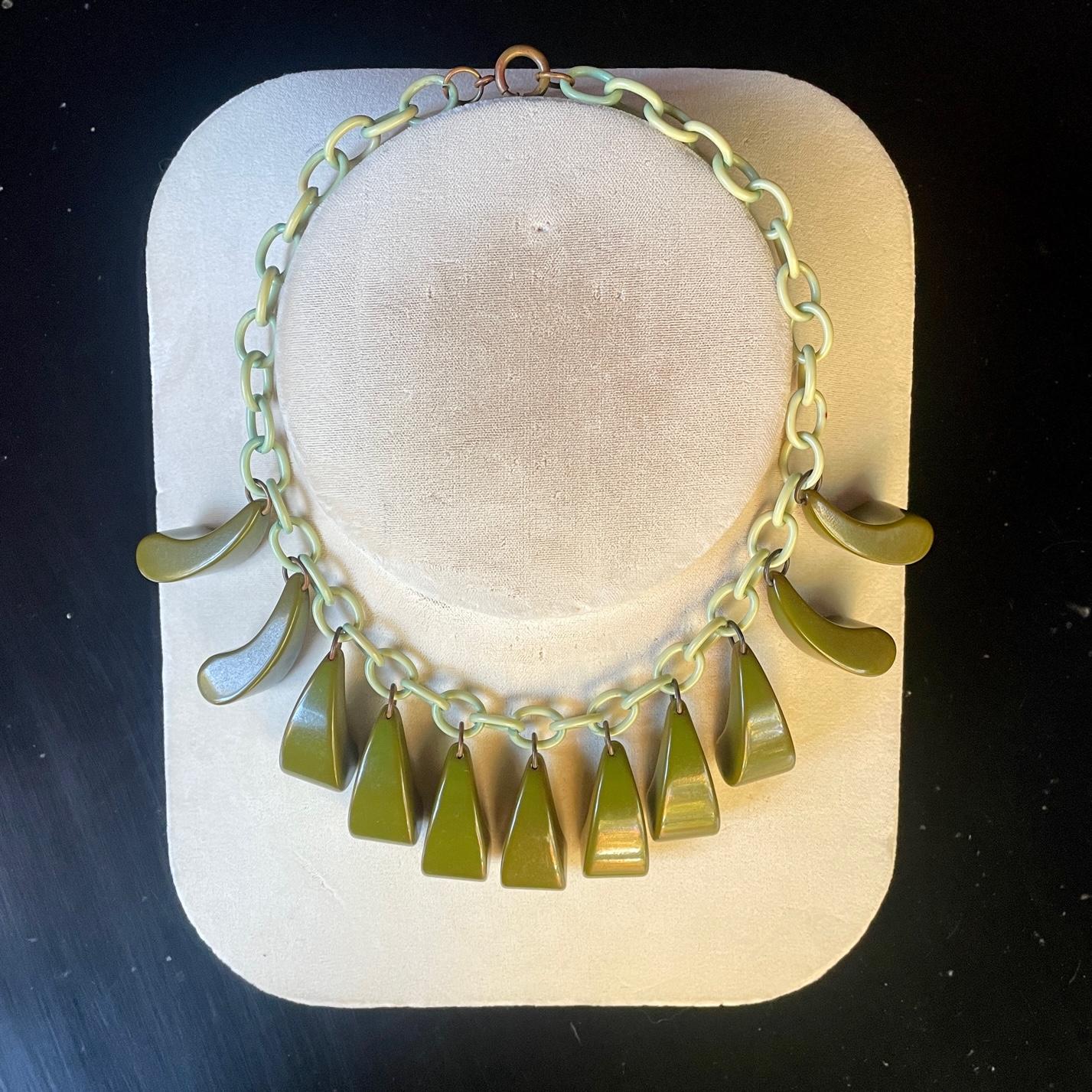USA c.1930s. Unknown Maker, possibly Mazor.   A light green Celluloid linked chain and (11) dark green Bakelite dangles. They have an organic feeling of arching reeds or arcing grass blades. American Industrial design mimicking and abstracting