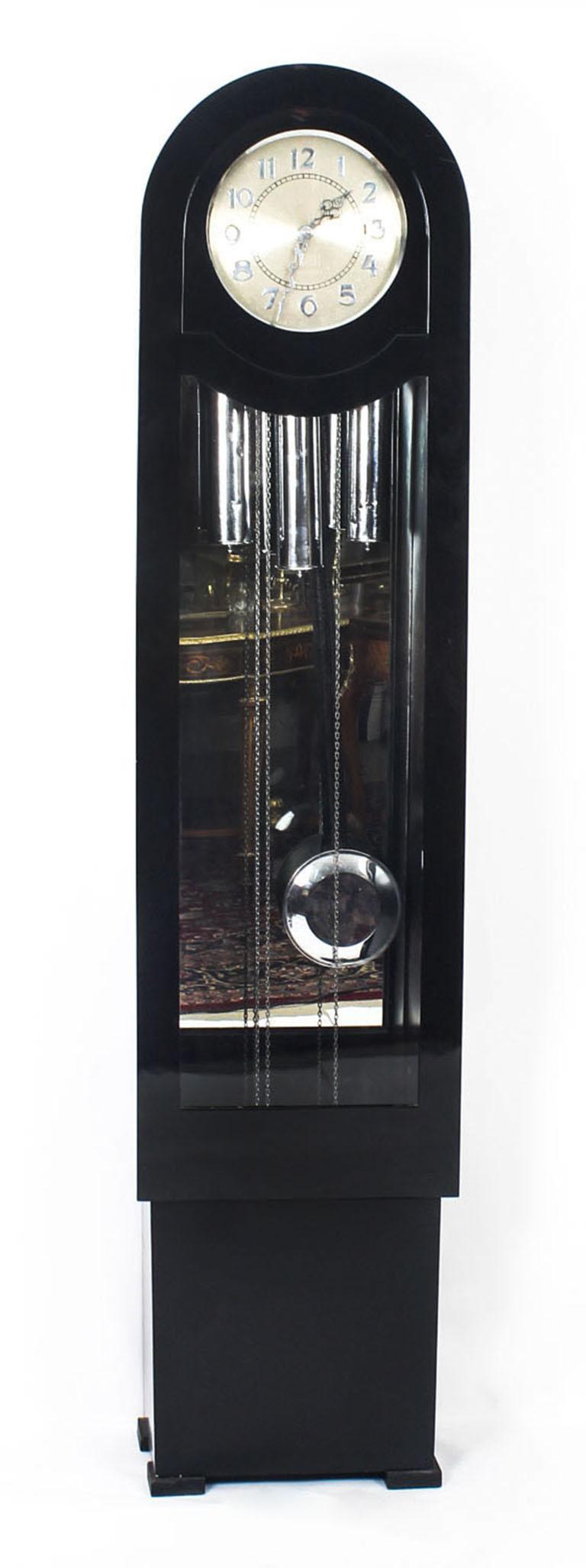 An elegant English Art Deco black lacquer Westminster chiming longcase clock made in London, circa 1935 in date.

The clock features a hinged glazed door on a boxed frame and a burnished silvered dial with chrome numerals.

It has three