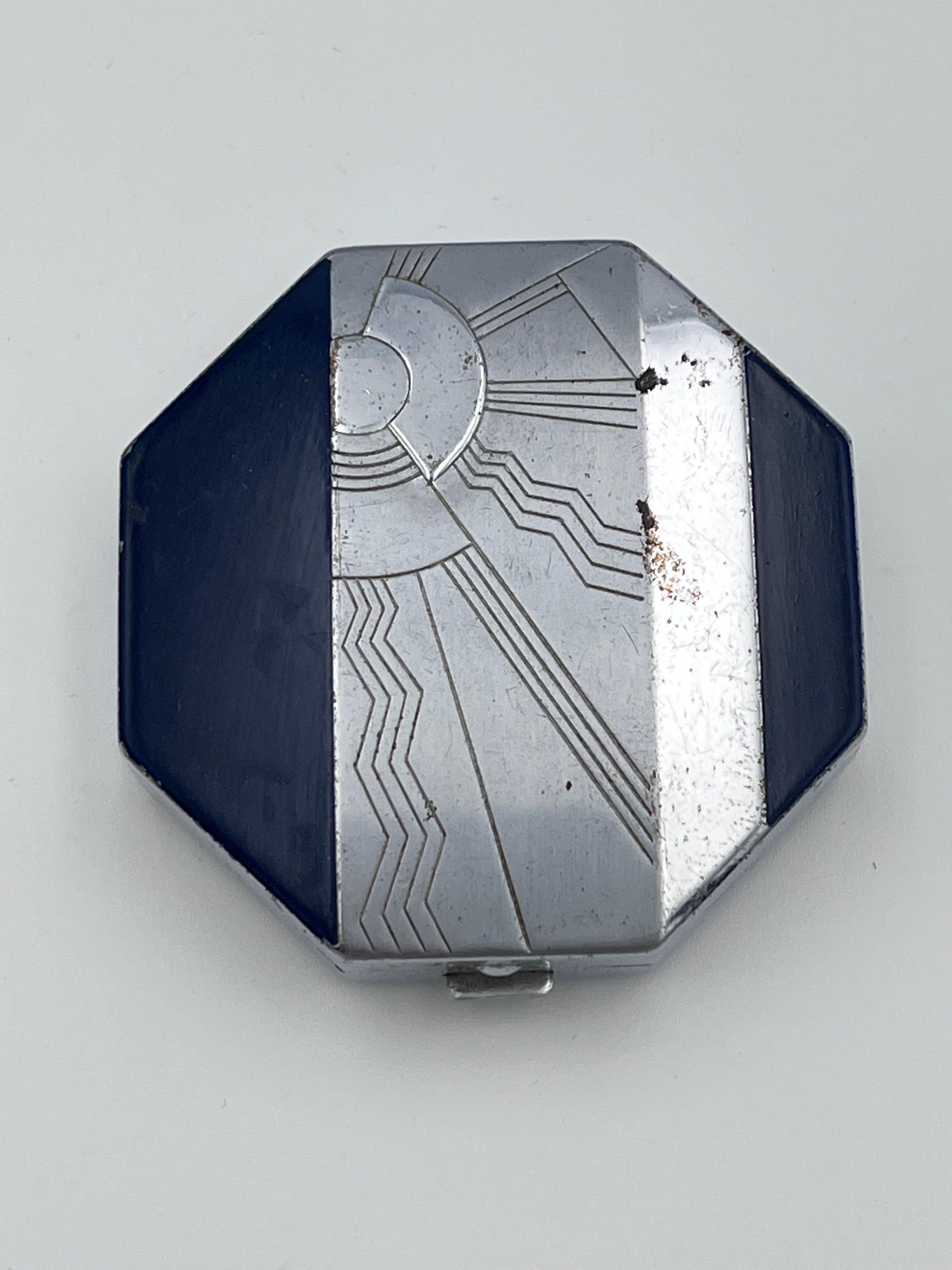 Bourjois Art Deco anni '30 Smalto blu marino e cromo, compatta per il trucco con cipria e pennello inutilizzati

Questa squisita compatta Bourjois Art Deco degli anni '30 esemplifica la raffinatezza e lo stile modernista dell'epoca. Realizzata in