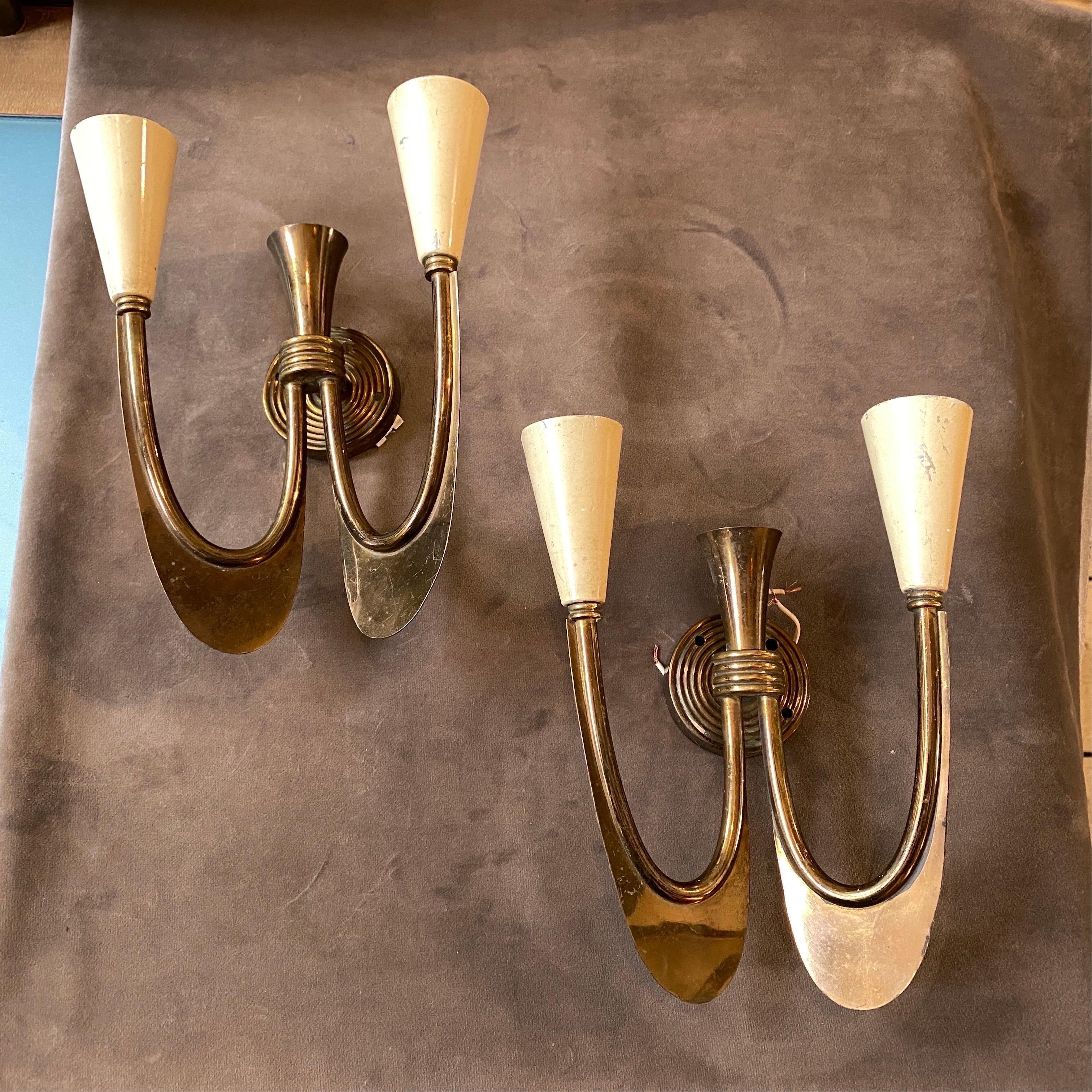 A pair of stylish Art Deco brass wall scones made in Italy in Thirties, brass it's in original patina, the two white diffusors need regular e14 bulbs, they work both 110-240 volts.