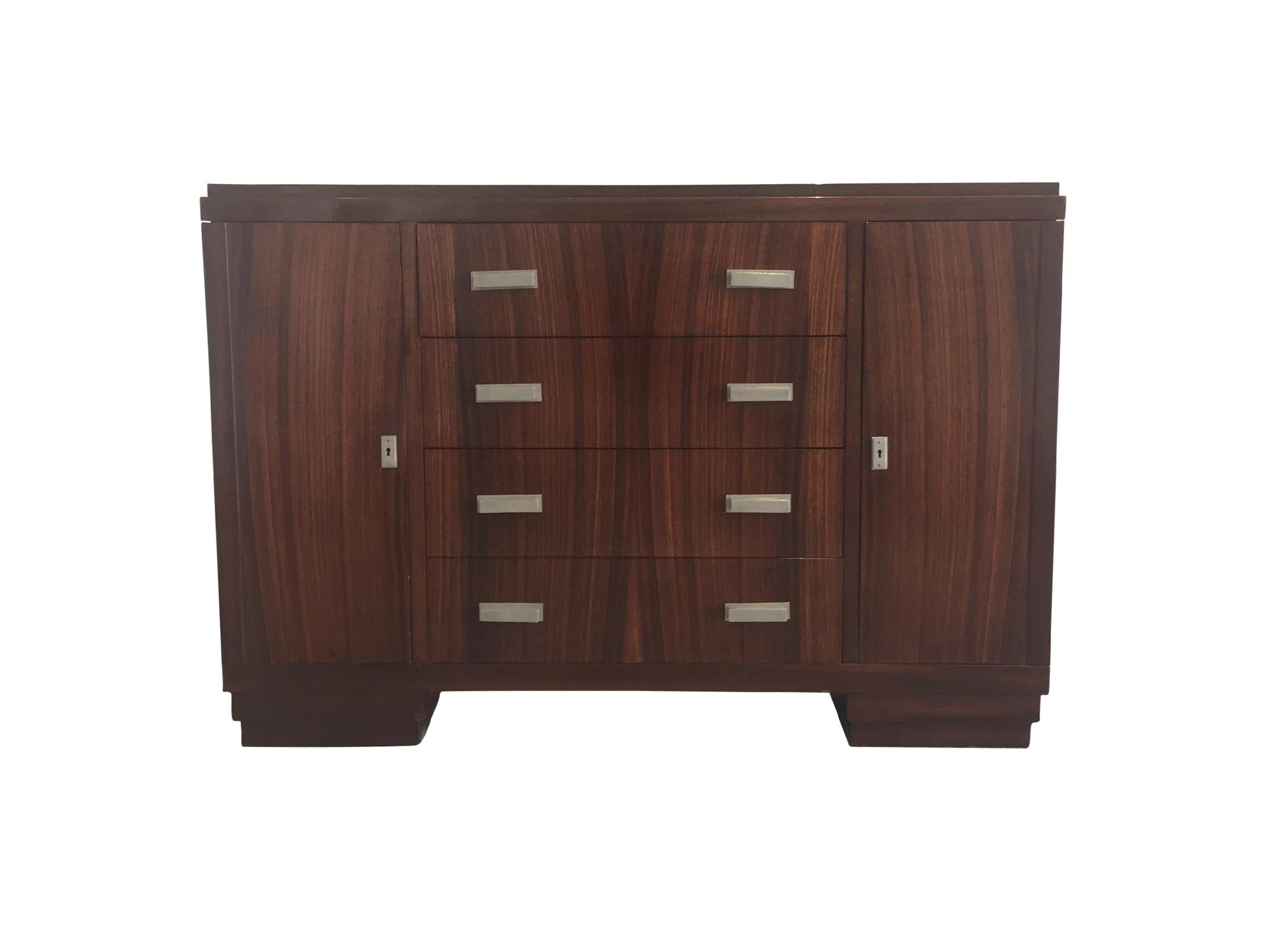 An exquisite French Art Deco cabinet or chest of drawers designed and made by Maison Soubrier in the 1930s. It is comprised of Macassar ebony wood in a warm reddish brown tone. The rare wood is known for its beautiful stripes, which here are modest,