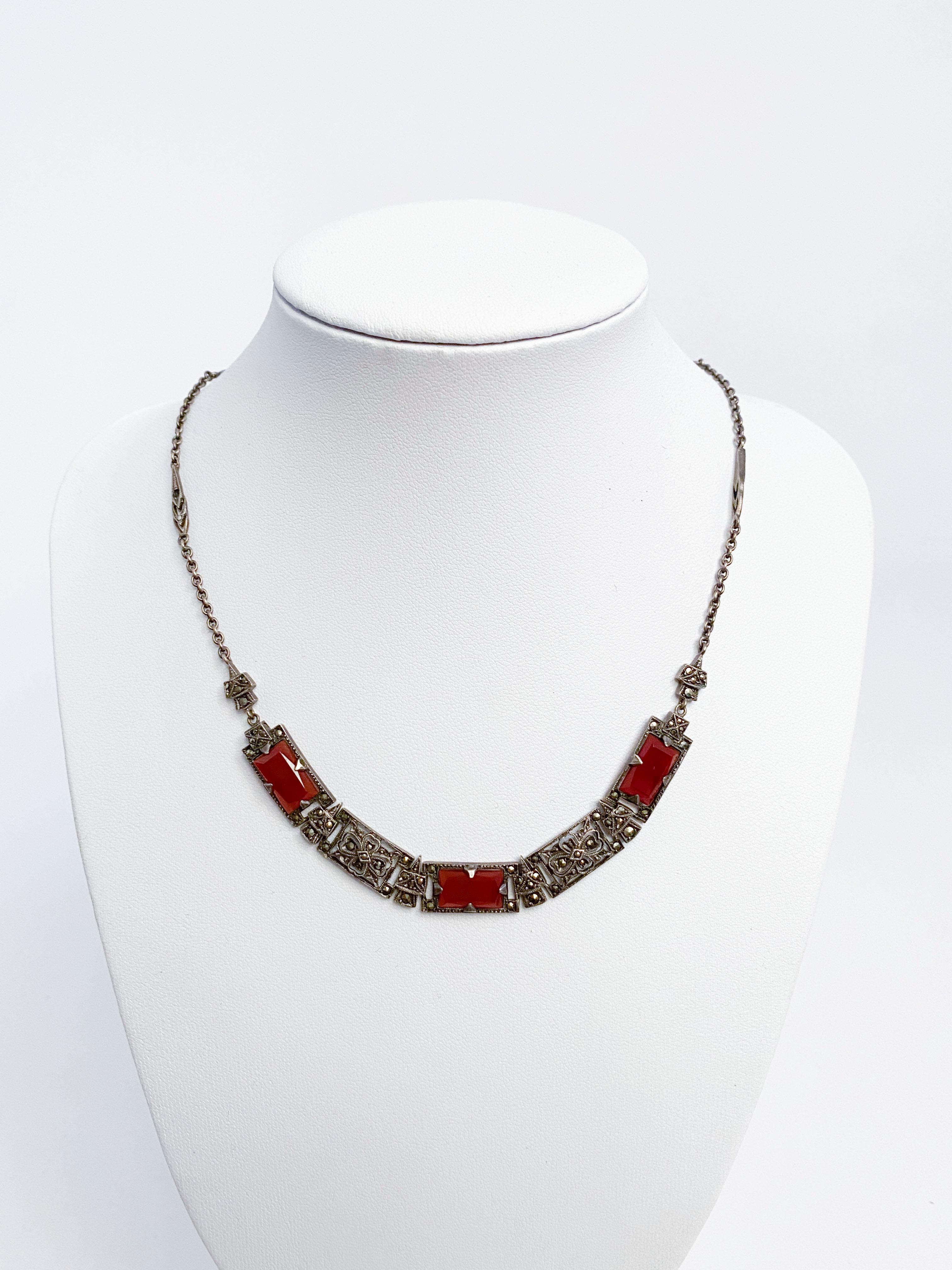 1930s three piece (necklace, bracelet, ring) set featuring carnelian and marcasites set in sterling silver decorated with filigree and cut out motives. The necklace has a closing clasp with a safety chain for extra measure.