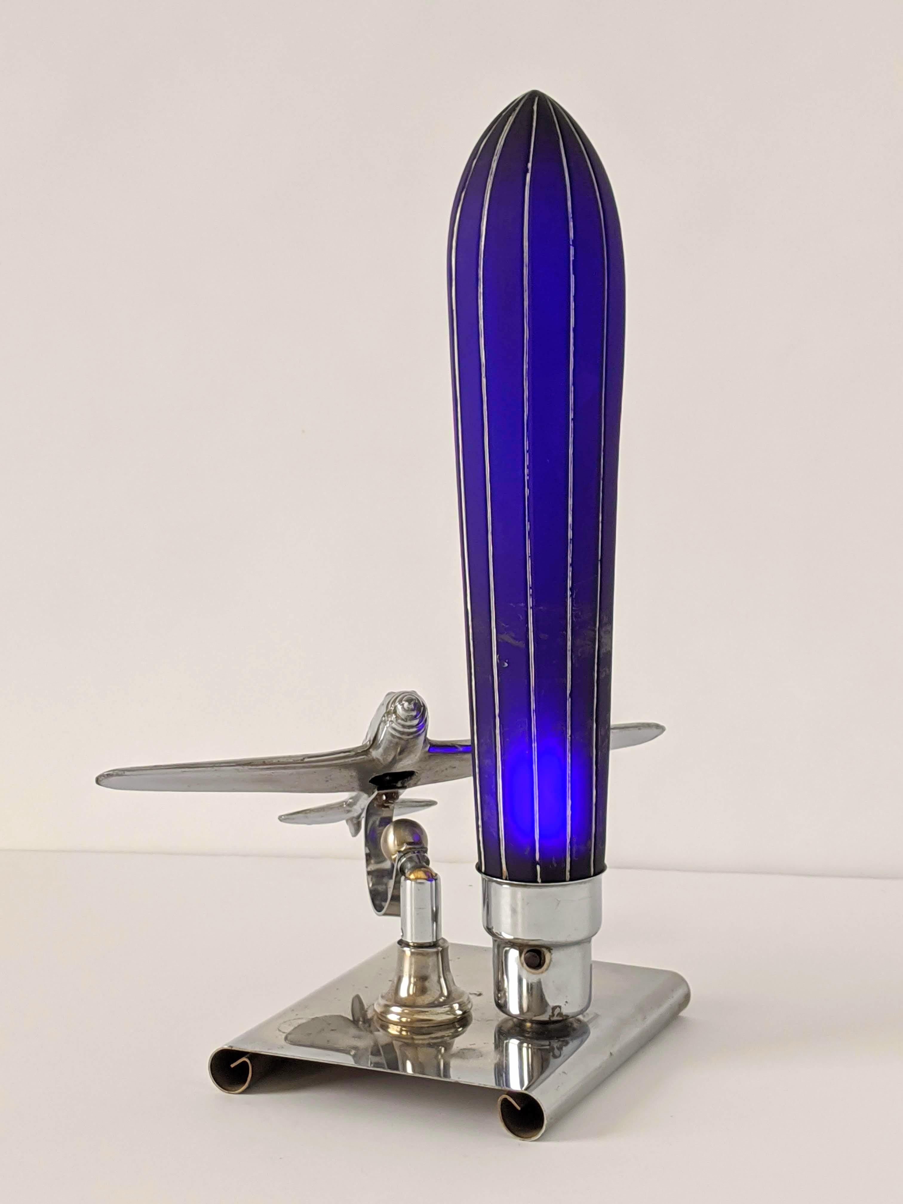 Aviation inspired art deco table lamp by Chicago designer Ray A. Schober. USA patented (Number on shade) in 1938 and 1940. This is a rare survivors with a cobalt blue glass shades with silver painted stripes manufactured by the Premium Products